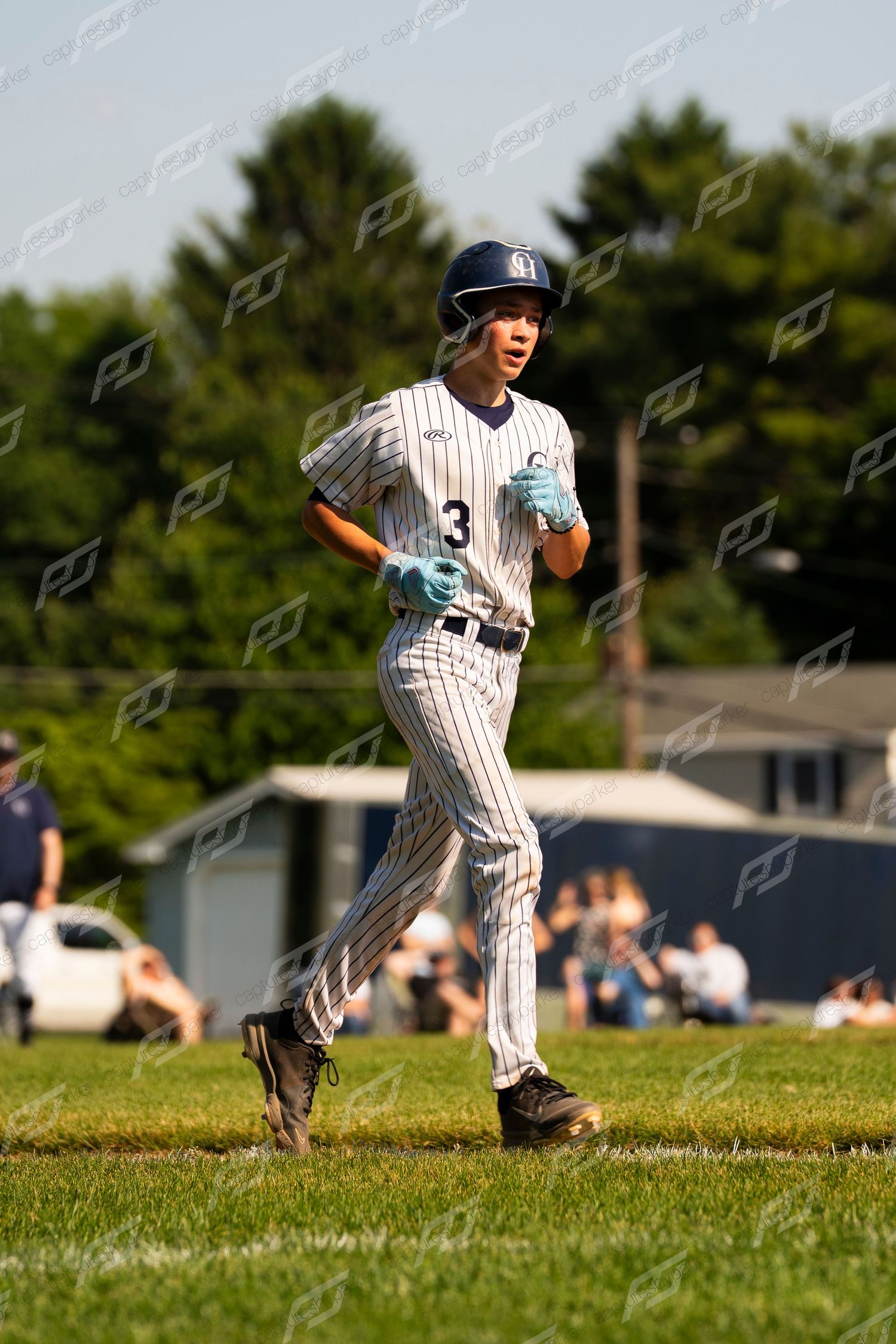 Baseball player #3 in pinstripe uniform running bases during a youth league game on a sunny day.