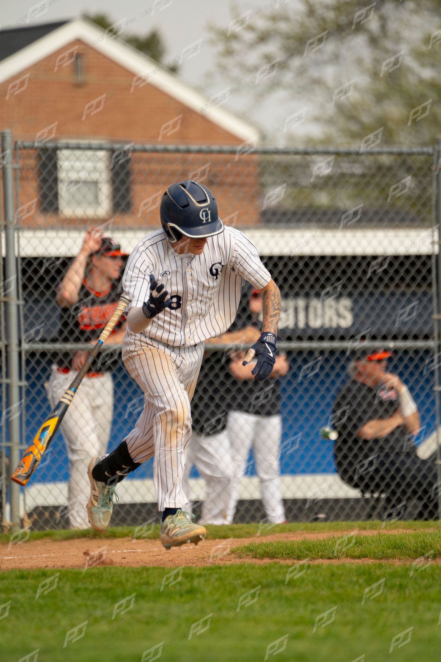 Baseball player in pinstripe uniform runs from home plate after making contact with the ball.