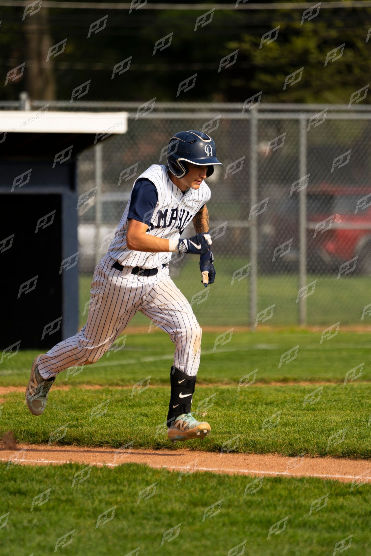 Camp Hill baseball player sprints along the baseline wearing a helmet during a game.