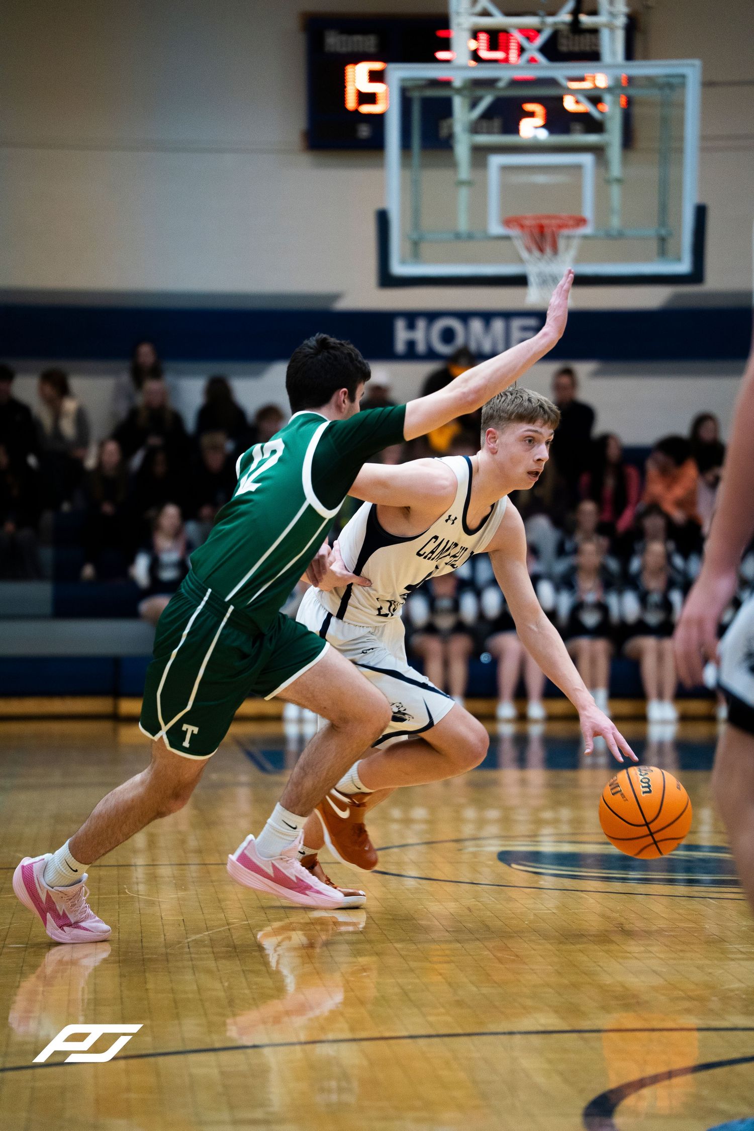 Camp Hill Lions guard drives past Trinity defender during competitive high school basketball game.