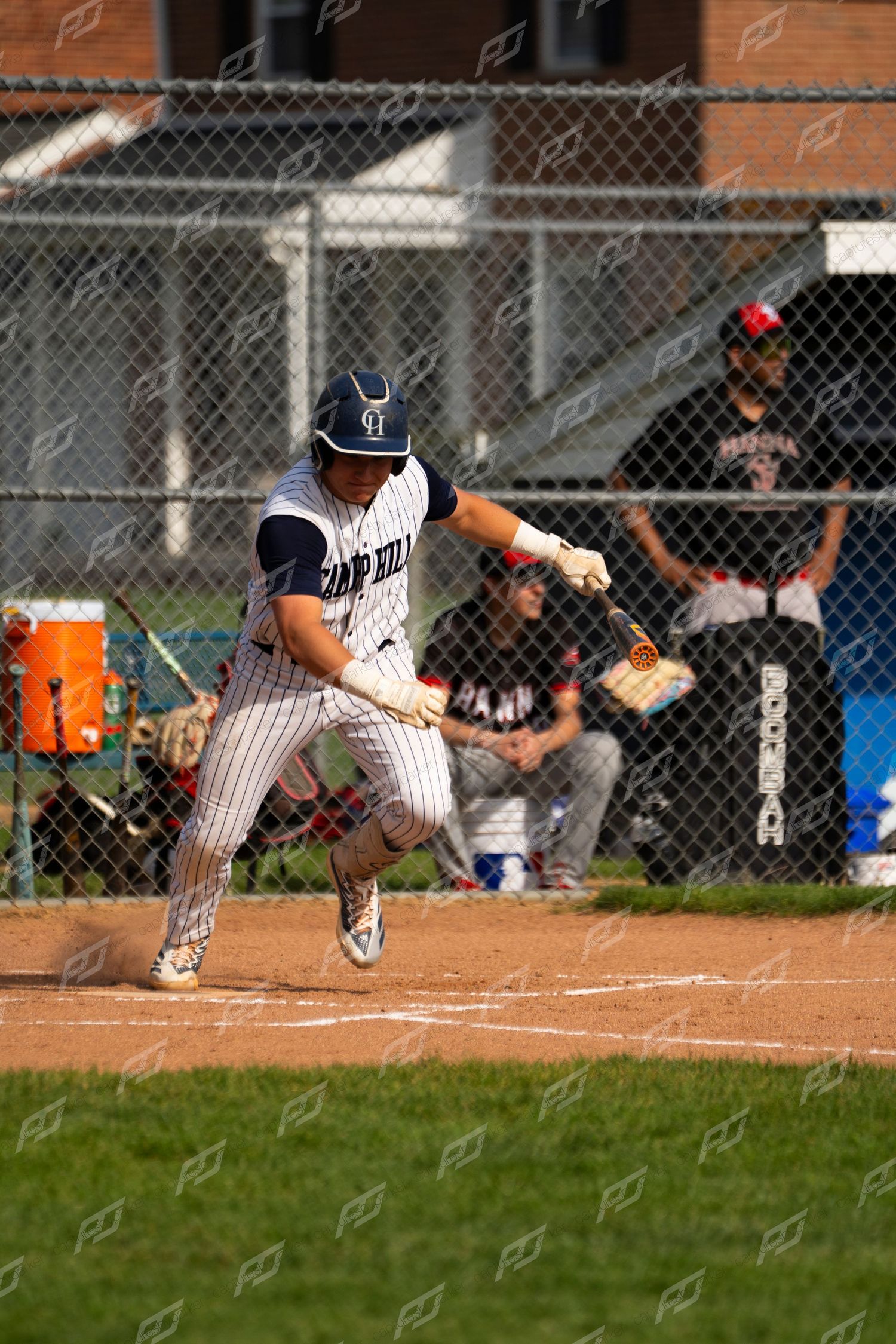 Camp Hill batter makes contact with the ball at home plate during a competitive baseball game.