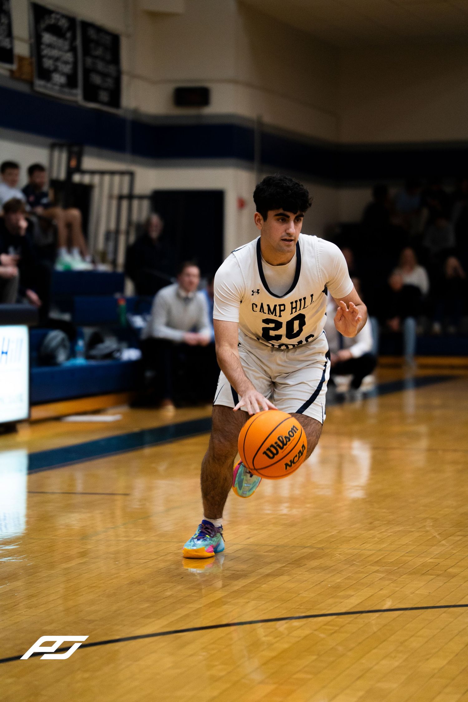 Camp Hill Lions number 20 dribbles the ball during a home basketball game.