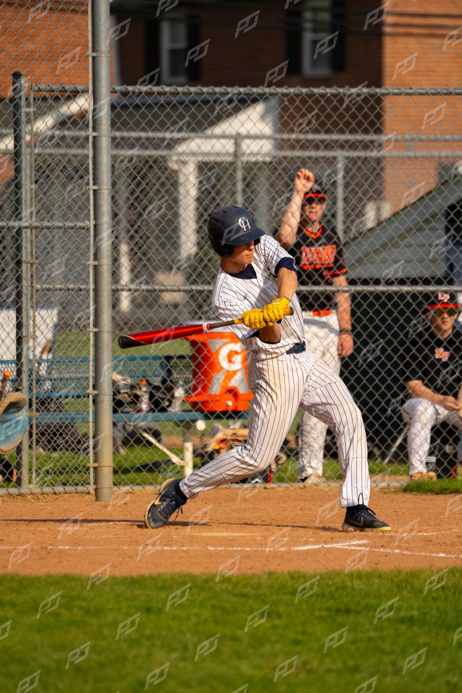 Young baseball player #16 in white pinstripe uniform making contact with pitch at home plate.