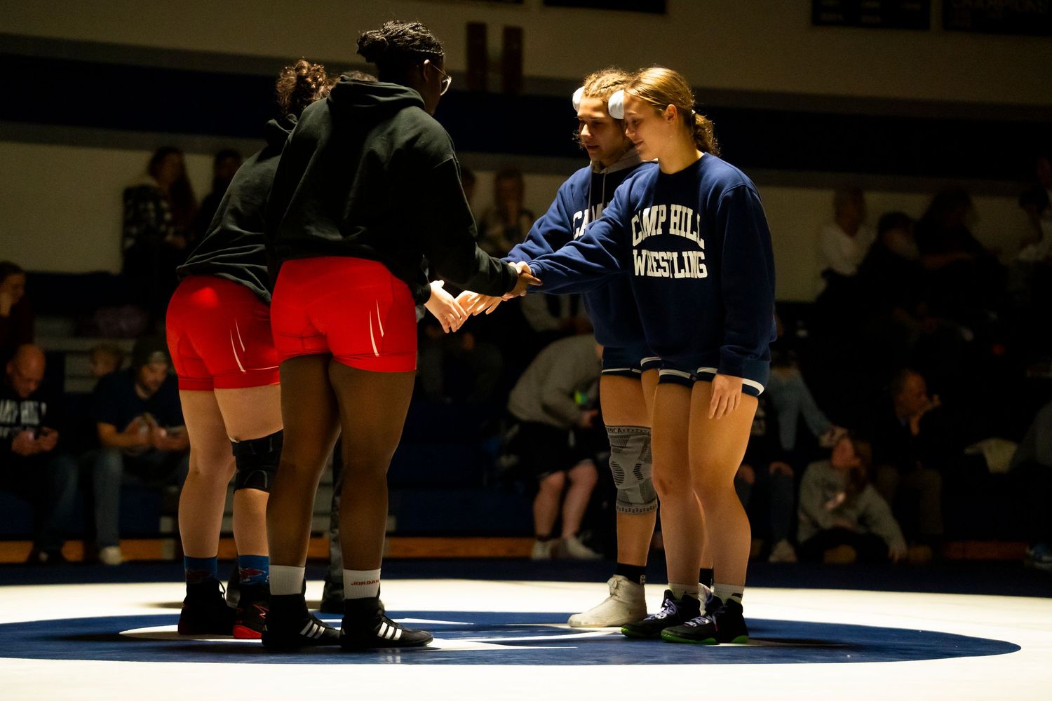 Camp Hill Wrestling team members shake hands with opponents before a match.