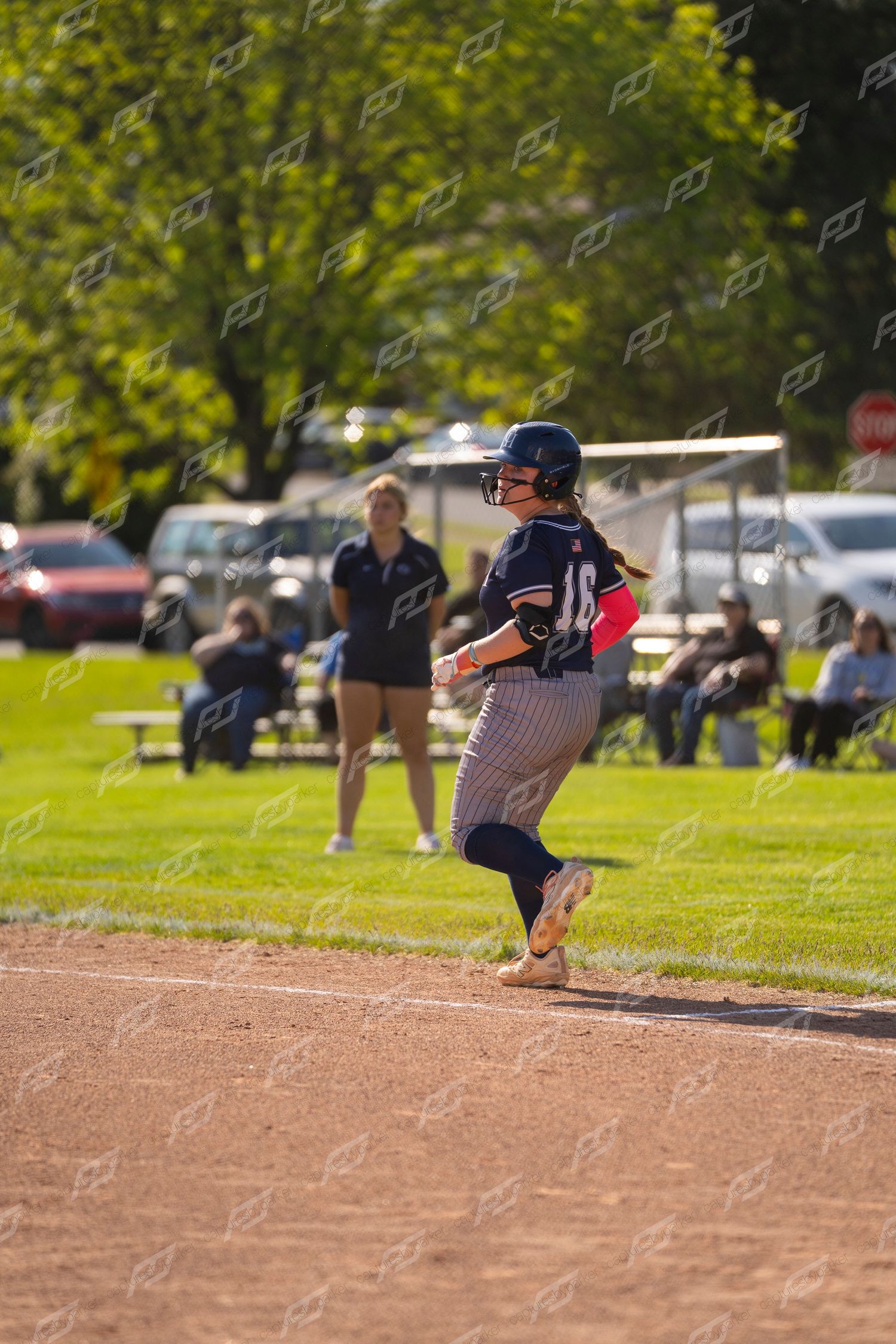 Female softball player wearing number 10 running the bases during a sunny outdoor game.