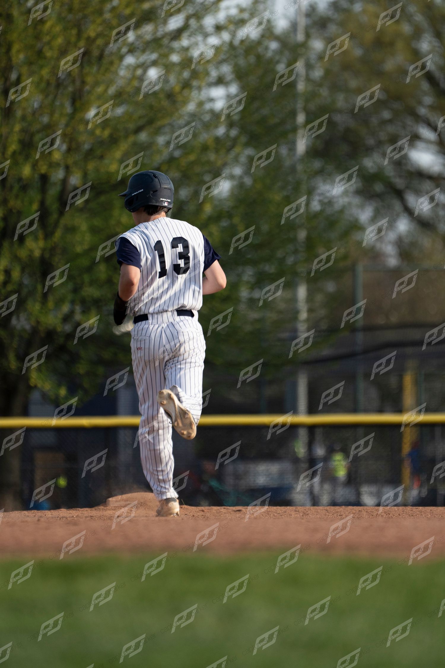 Camp Hill baseball player number 13 jogs along the baseline during a game.