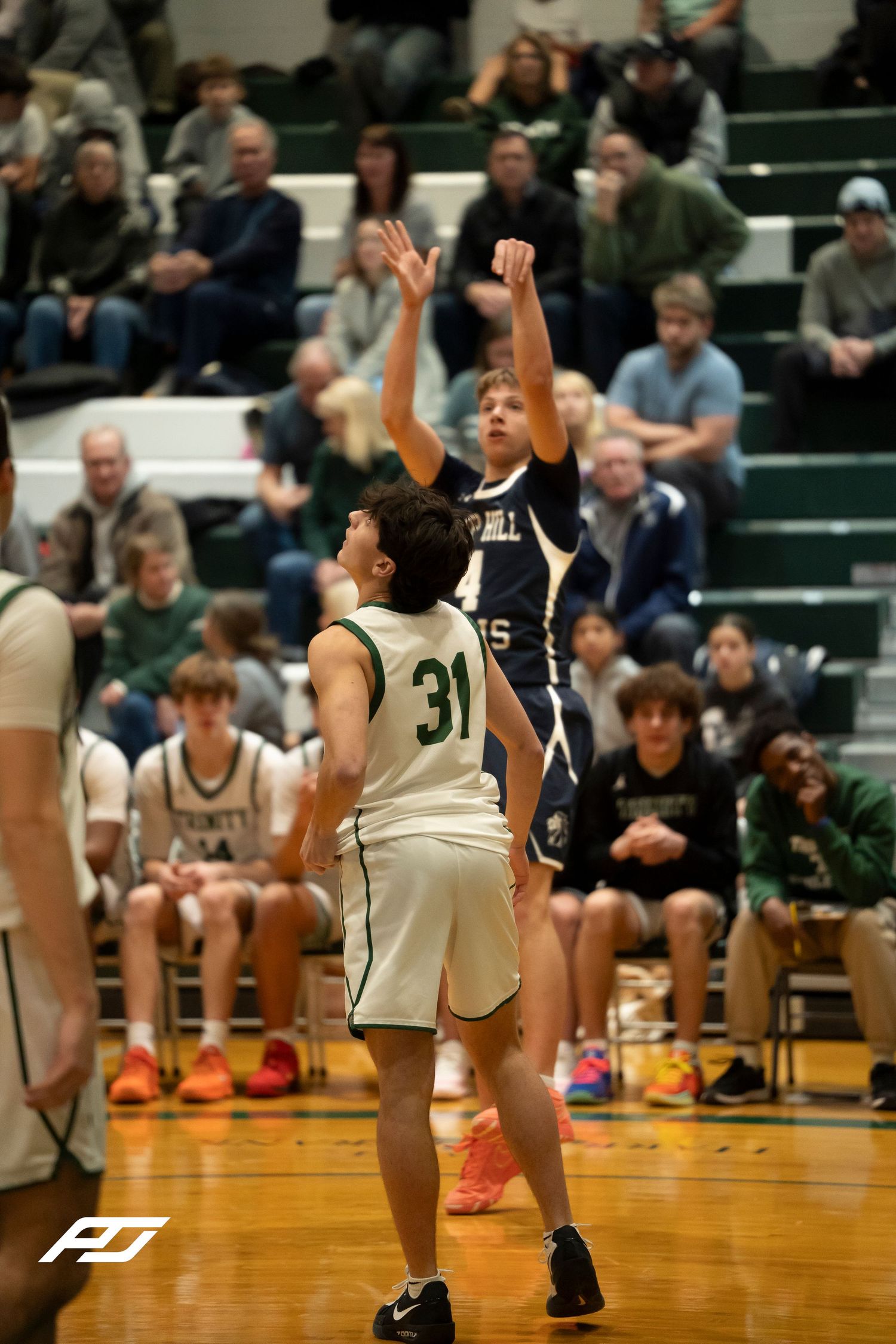 Camp Hill Lions player shoots over Trinity number 31 during a high school basketball game.