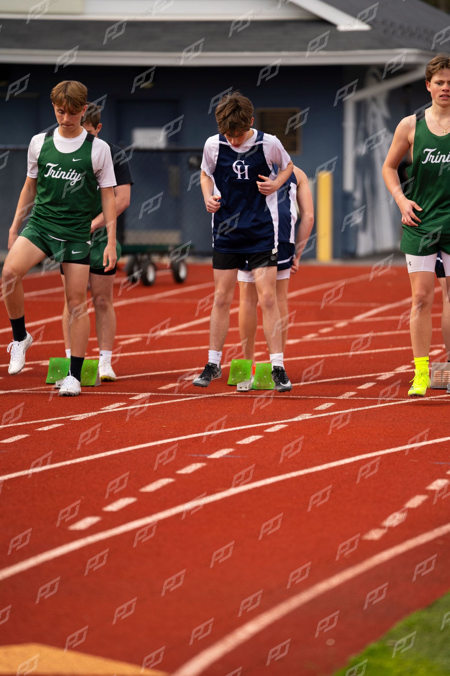 Trinity and CH high school track athletes prepare at starting line on red track near Kunkel Field House.