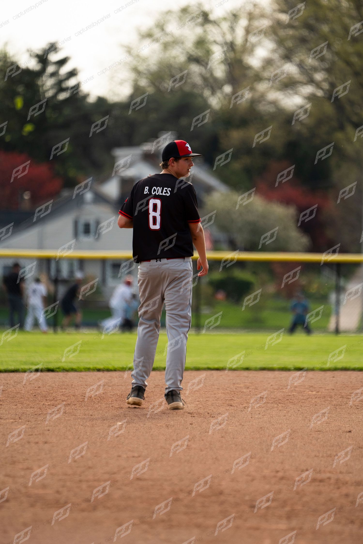 Baseball player B. Coles number 8 in black uniform stands at second base during an outdoor game.