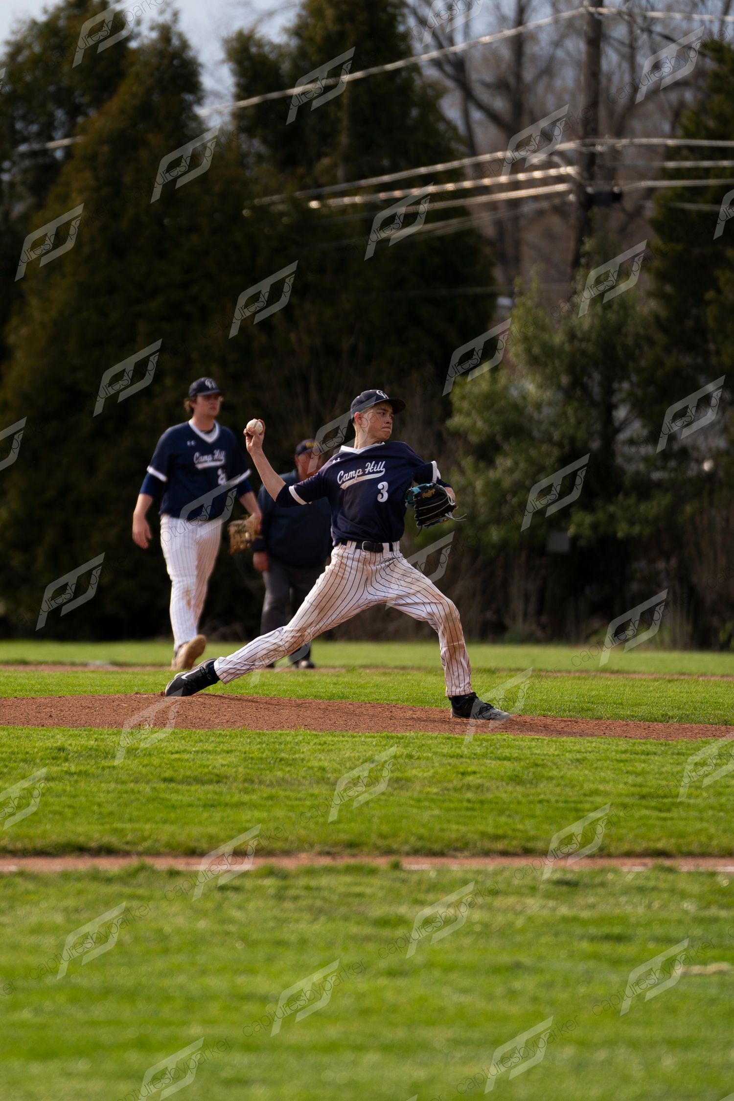 Baseball pitcher in navy pinstripe uniform #3 delivering a pitch on the mound.