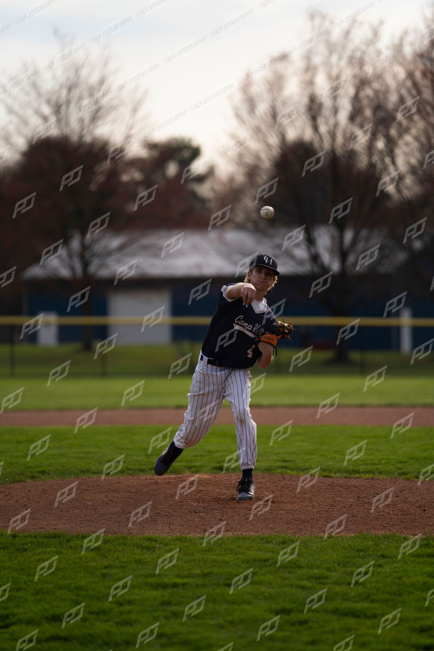 Baseball infielder throws the ball across the diamond during an outdoor game.
