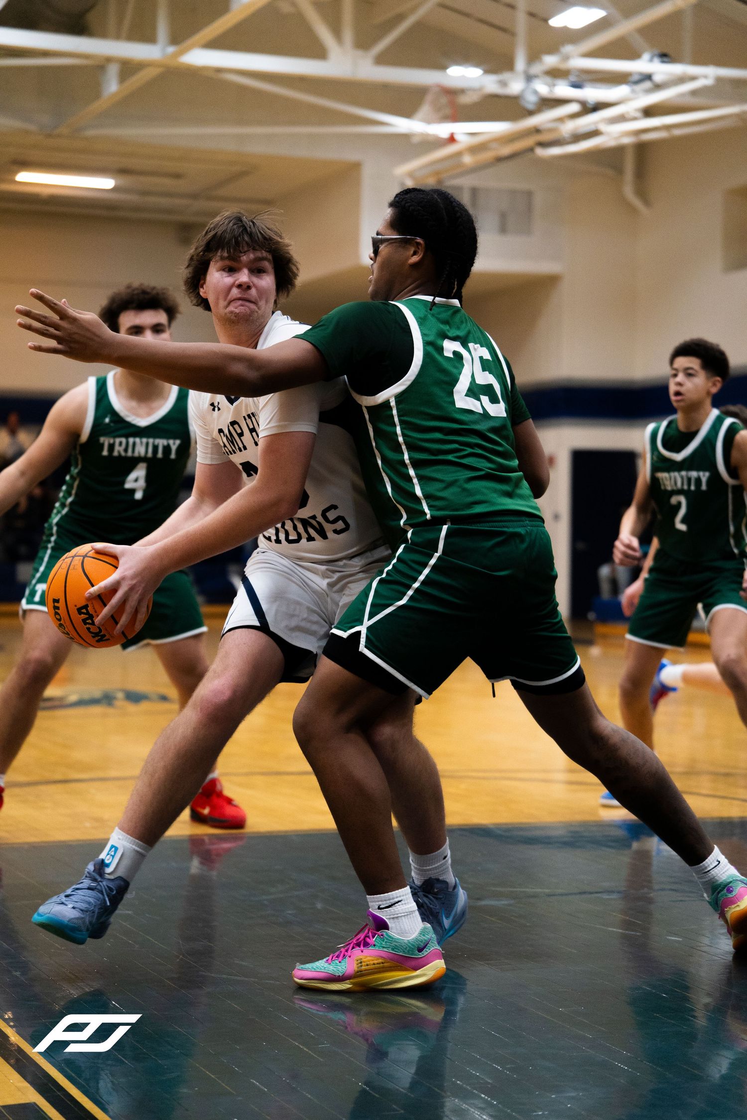 Camp Hill Lions player battles Trinity #25 defender in the post during high school basketball game.