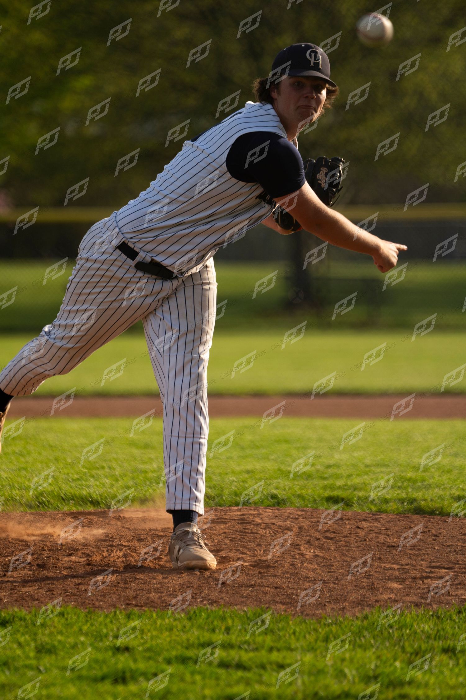Camp Hill baseball pitcher delivers a pitch during a game on a sunny day.