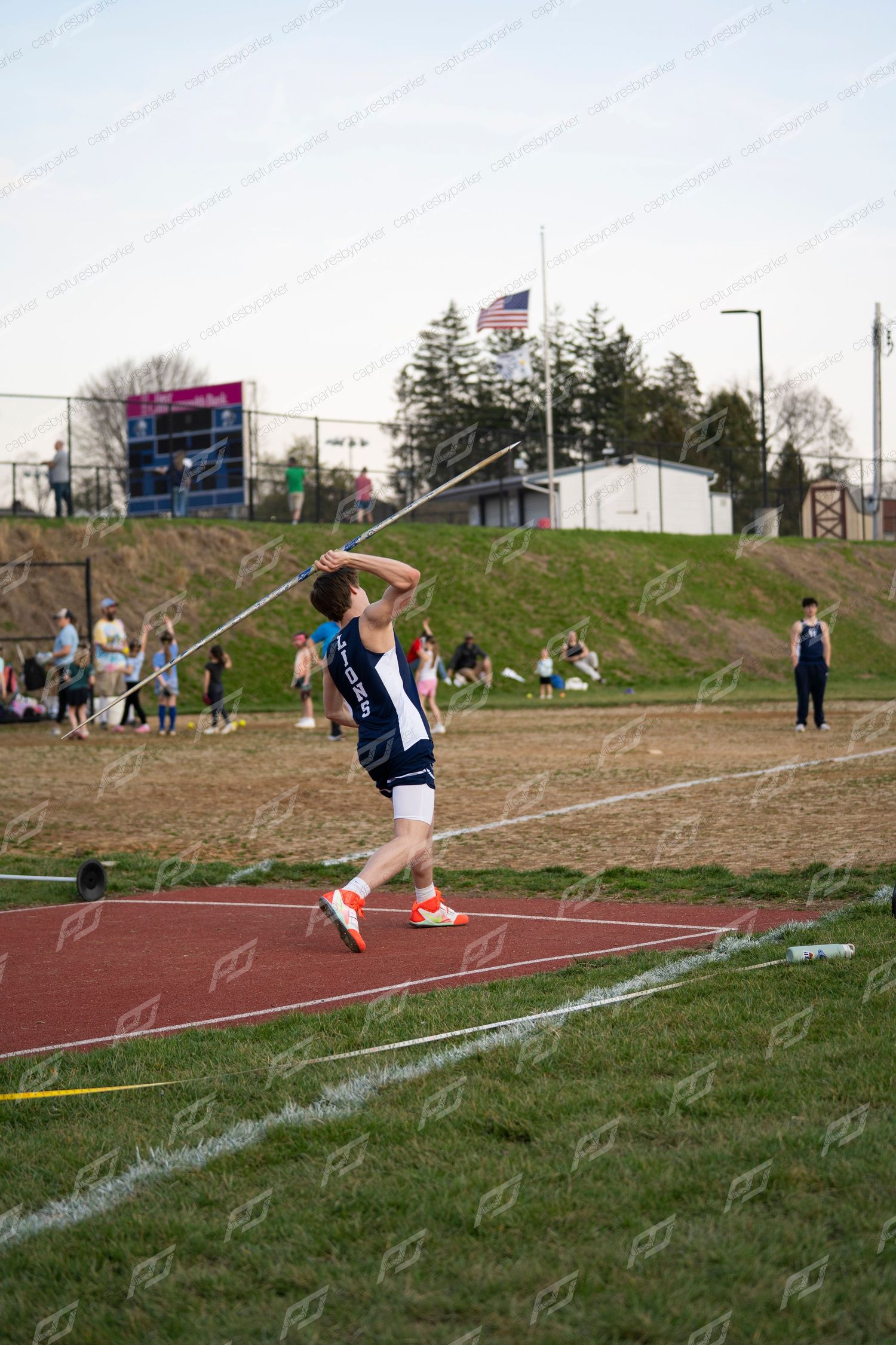 Male athlete releasing javelin at outdoor track and field competition.