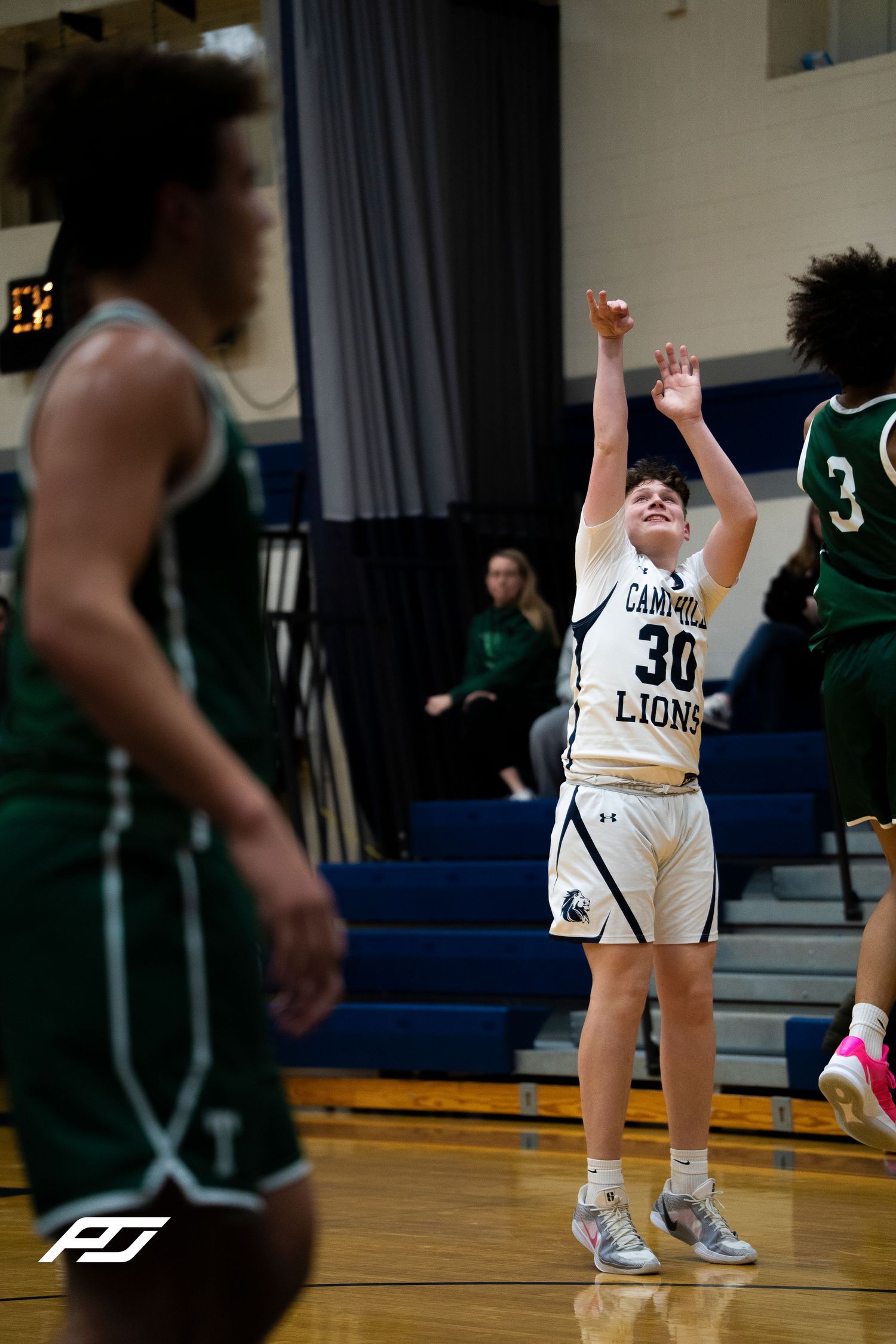 Camp Hill Lions #30 shoots free throw against Trinity defenders during high school basketball game.