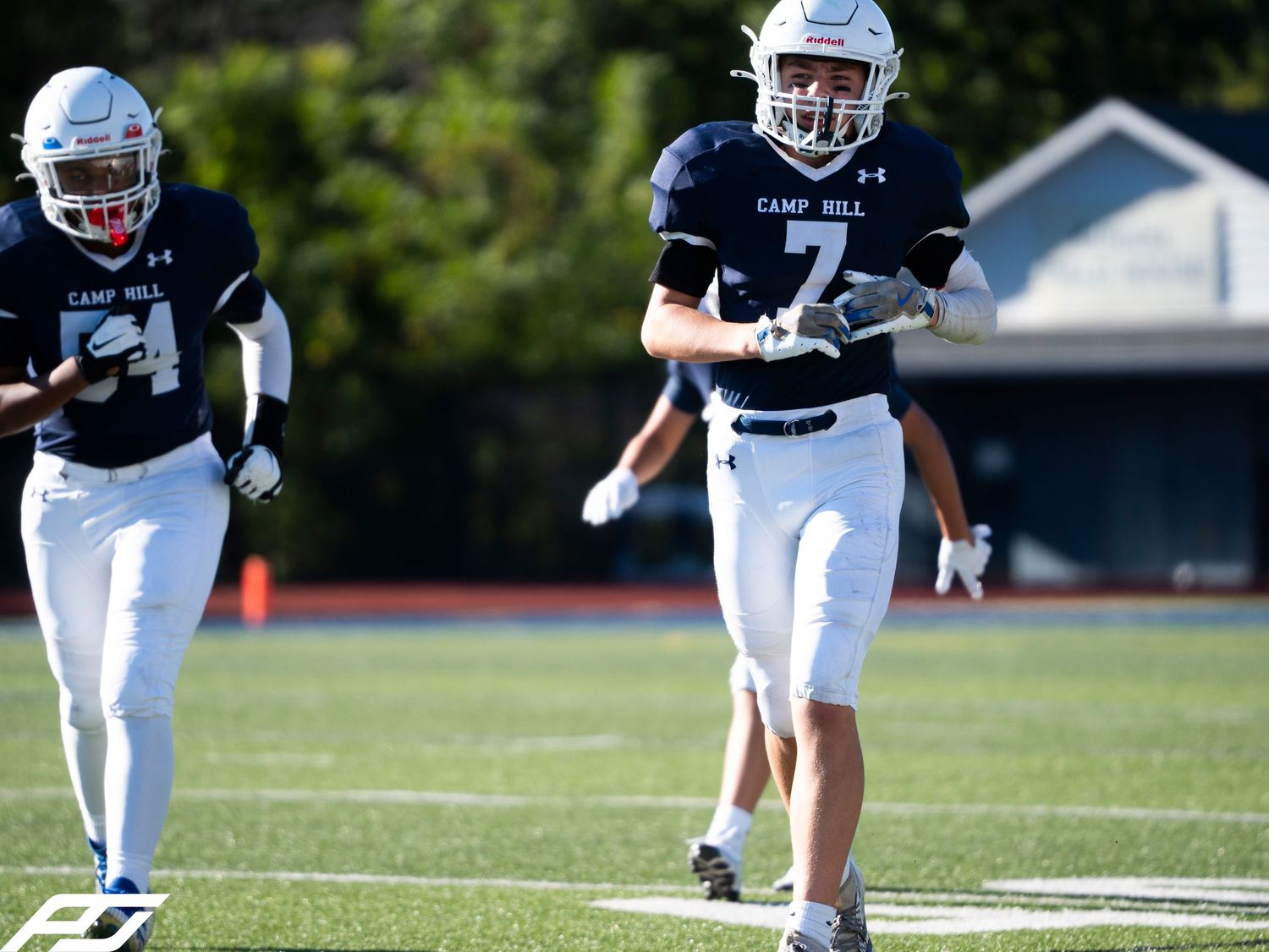 Camp Hill football player #7 runs on field in navy and white uniform during game.