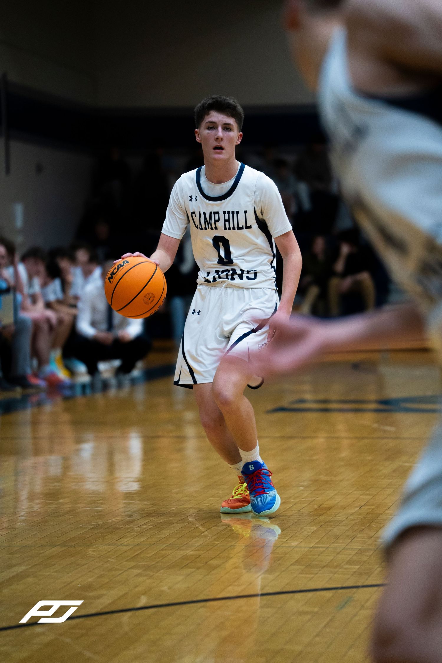 Camp Hill Lions number 0 dribbles upcourt during a high school basketball game.