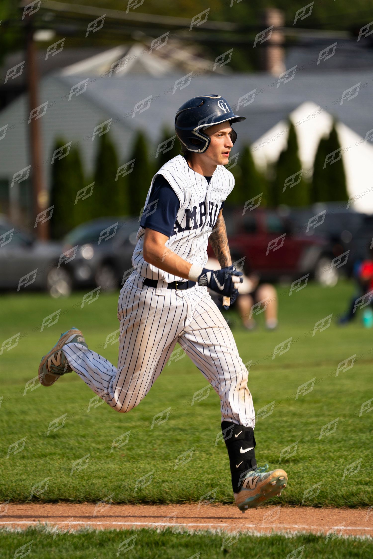Camp Hill baseball player runs the bases with a smile during an outdoor game.