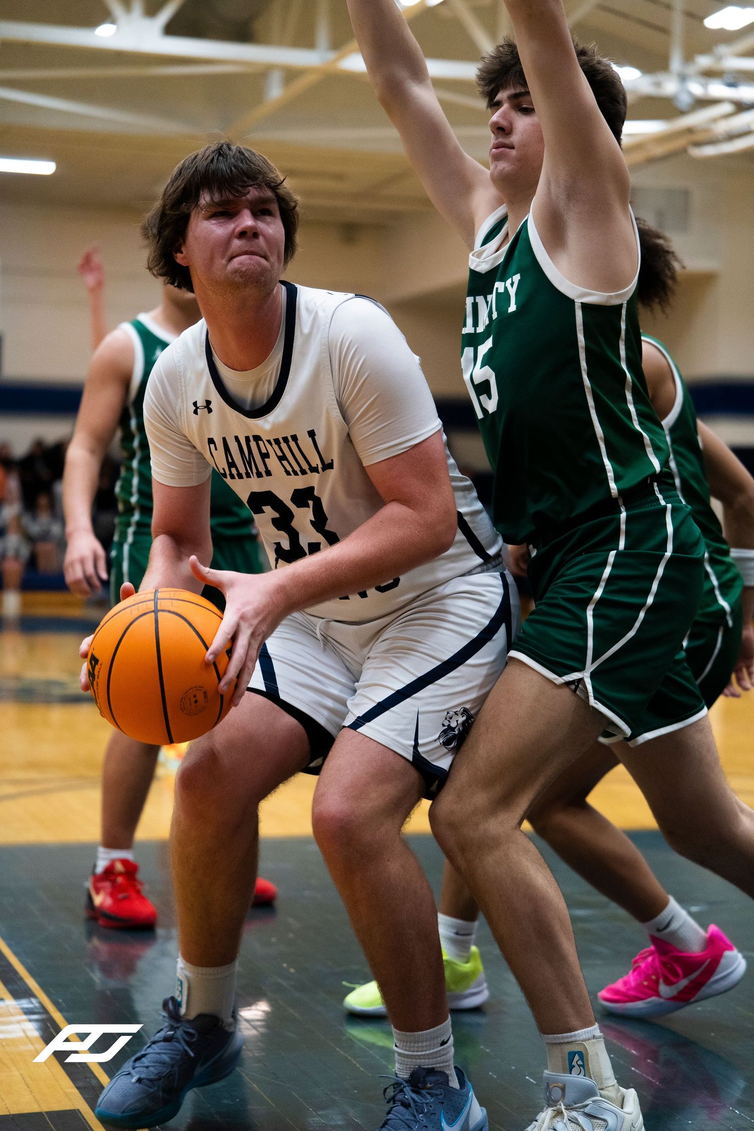 Camp Hill Lions #33 drives to basket against Trinity defenders during high school basketball game.