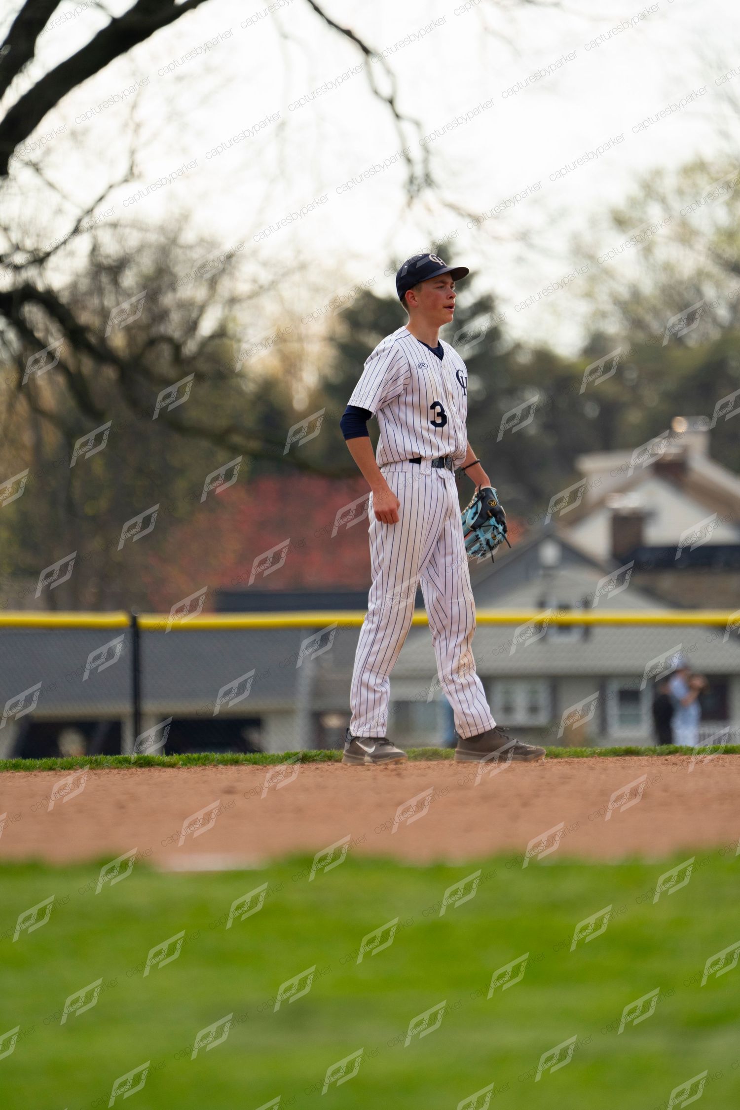 Baseball player number 3 in pinstripe uniform standing alert in the outfield.