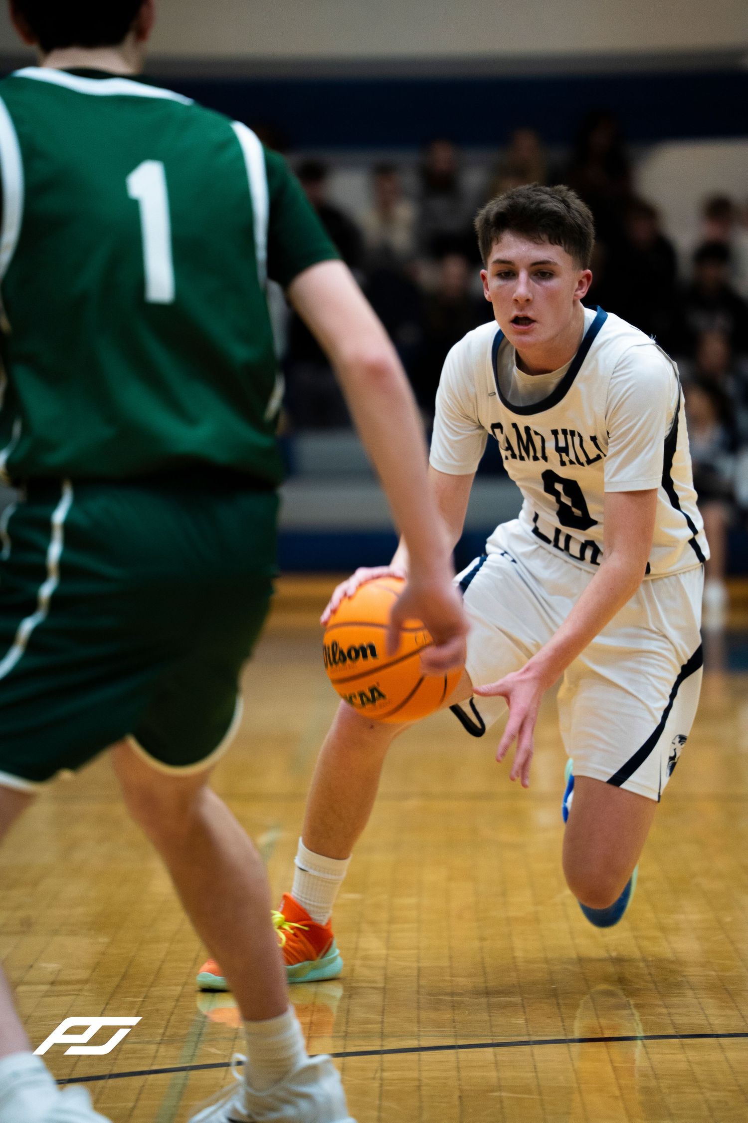 Camp Hill Lions #3 dribbles the ball toward a defender during a high school basketball game.