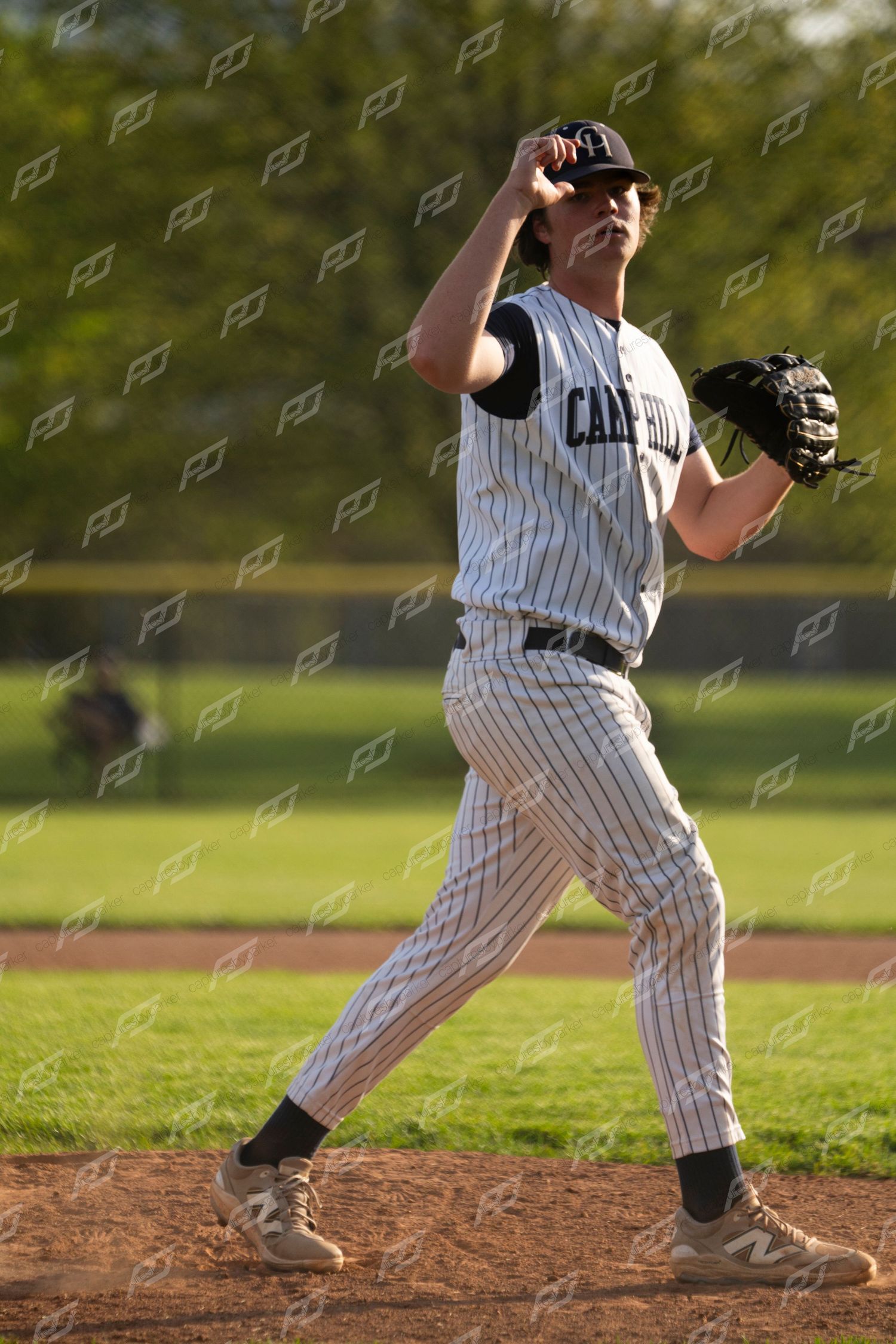 Camp Hill baseball pitcher winds up for a throw on the mound during a game.