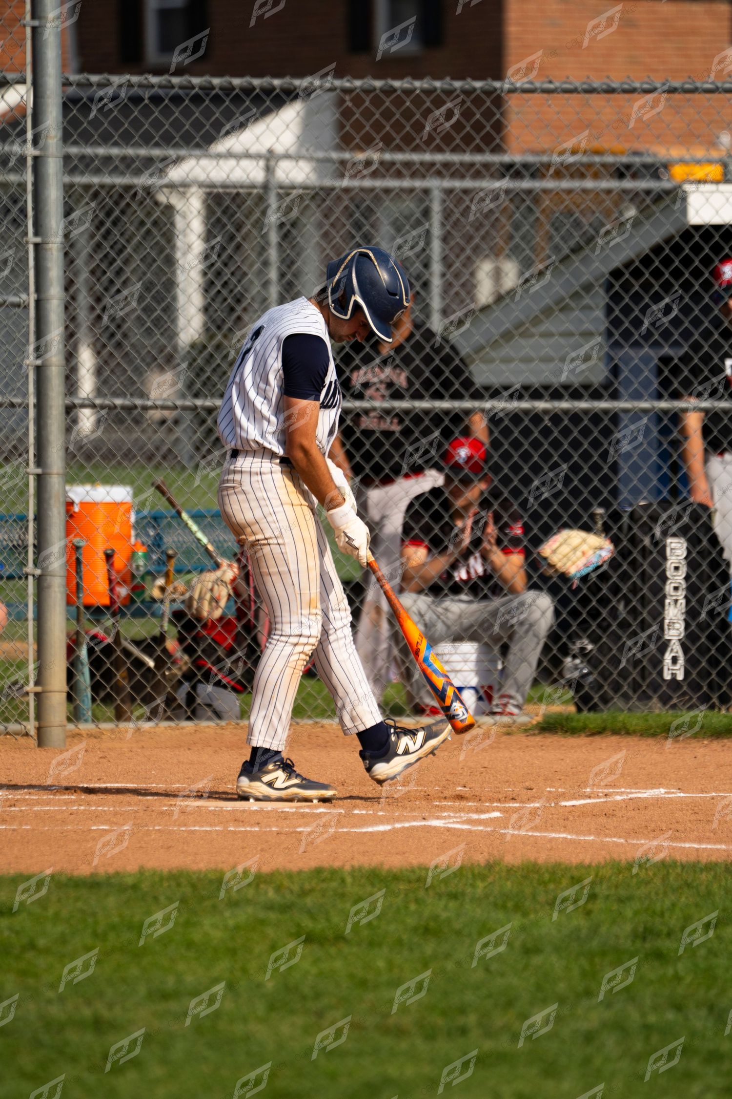 Baseball batter in white pinstripe uniform prepares to swing at home plate during a game.
