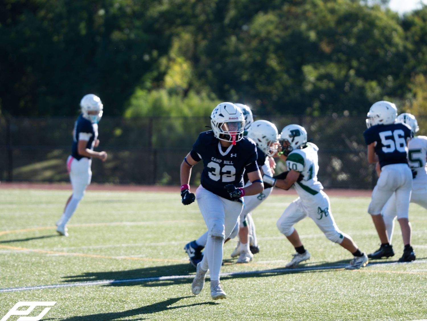 Camp Hill youth football player number 32 runs with the ball during a game.