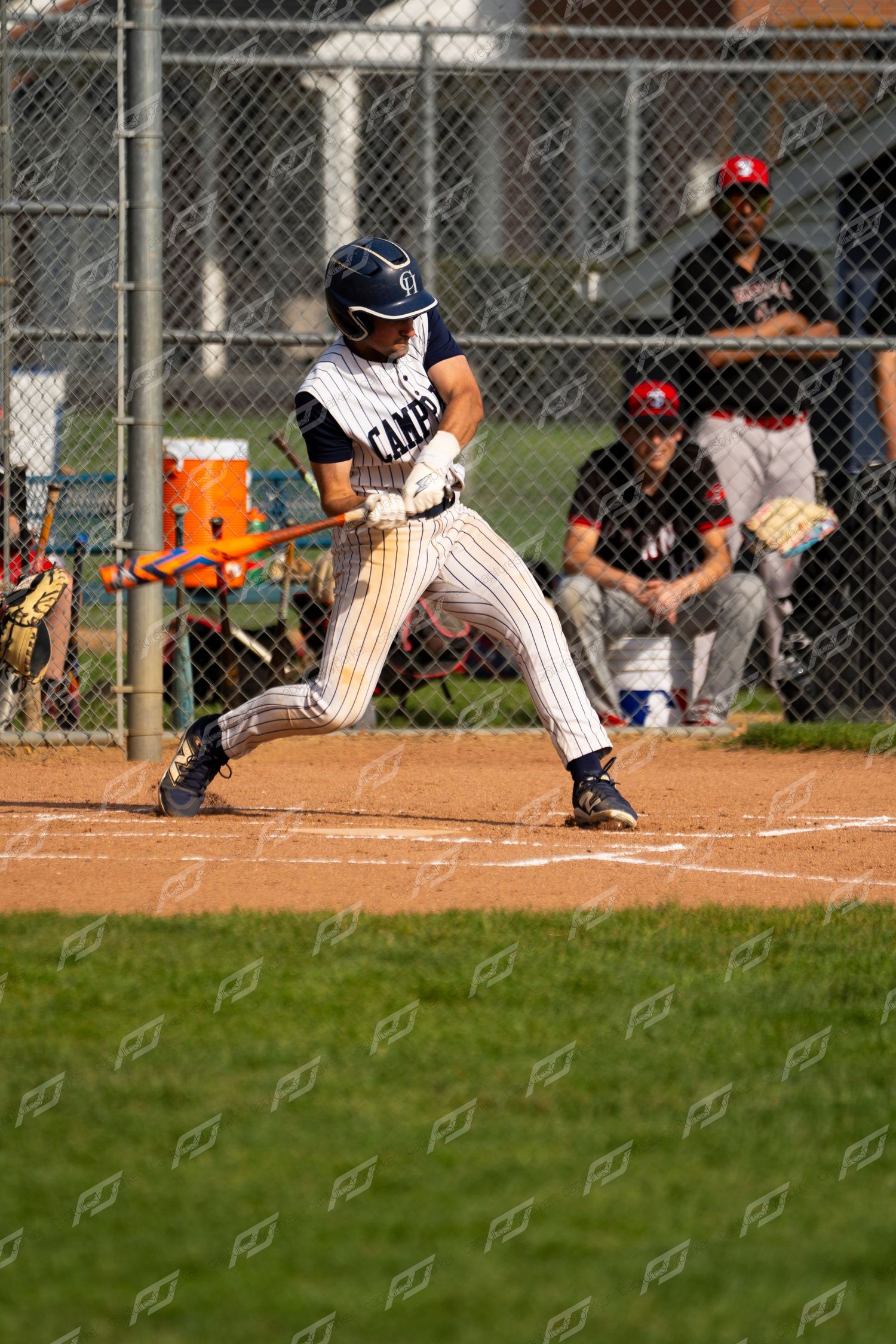 Camp Hill baseball player swings an orange bat at home plate during a youth baseball game.
