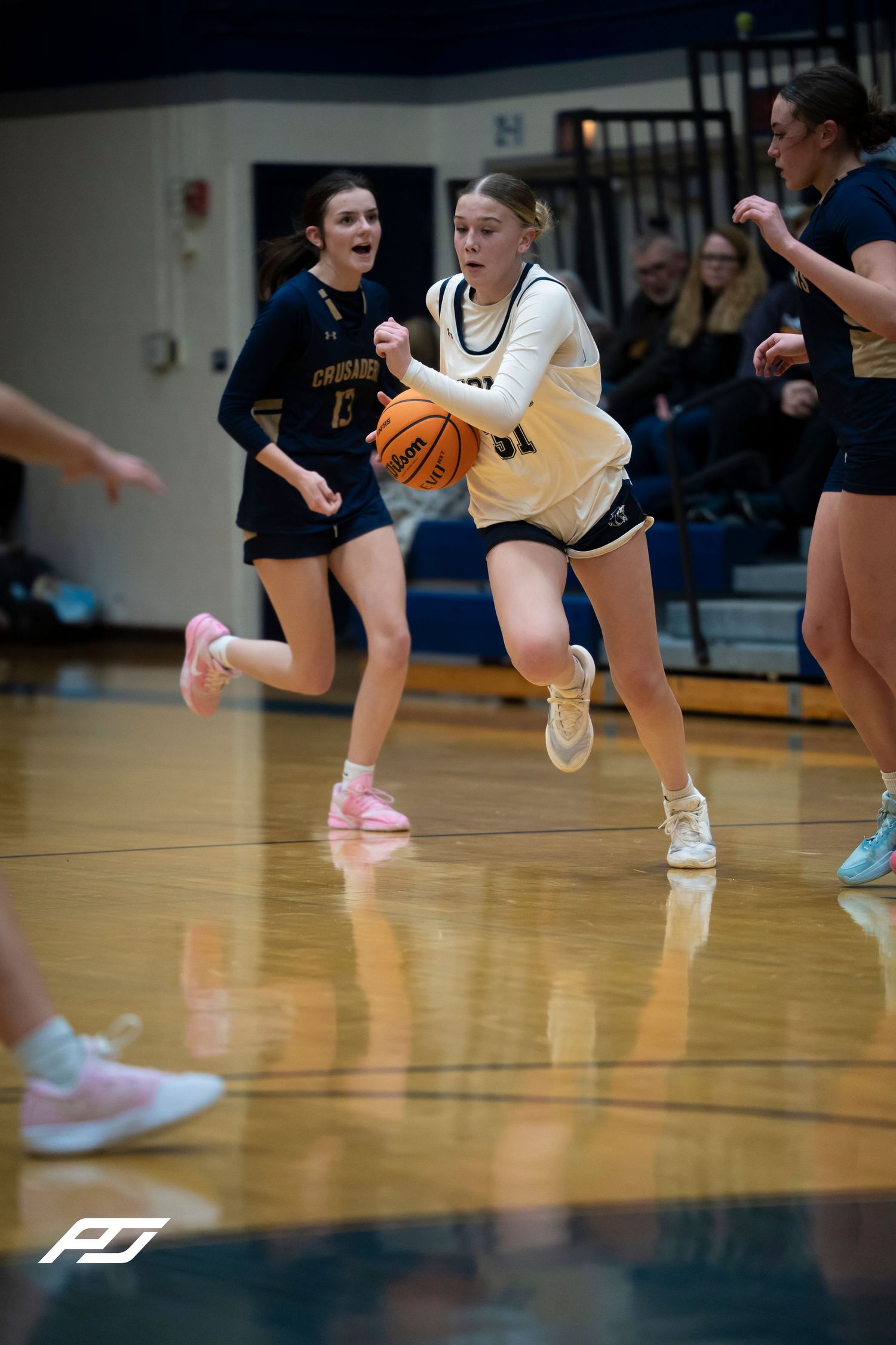 Lions girls basketball player dribbles upcourt during a game against the Crusaders.