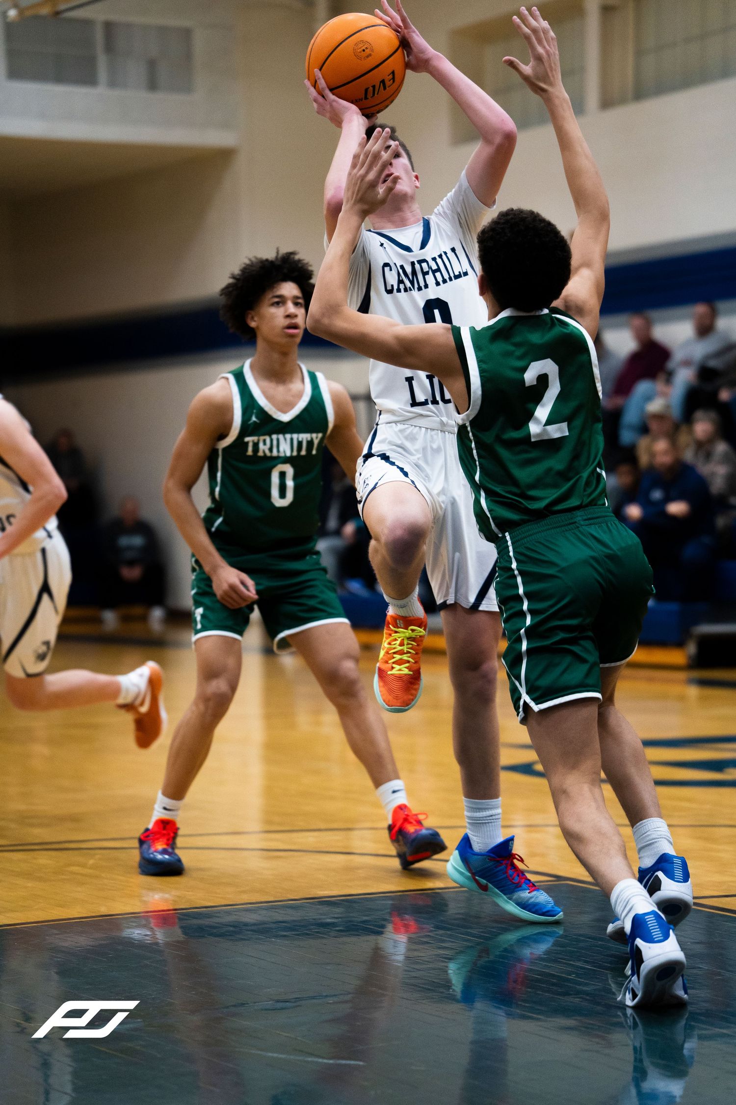 Camp Hill Lions player drives to the basket against Trinity defender number 2.