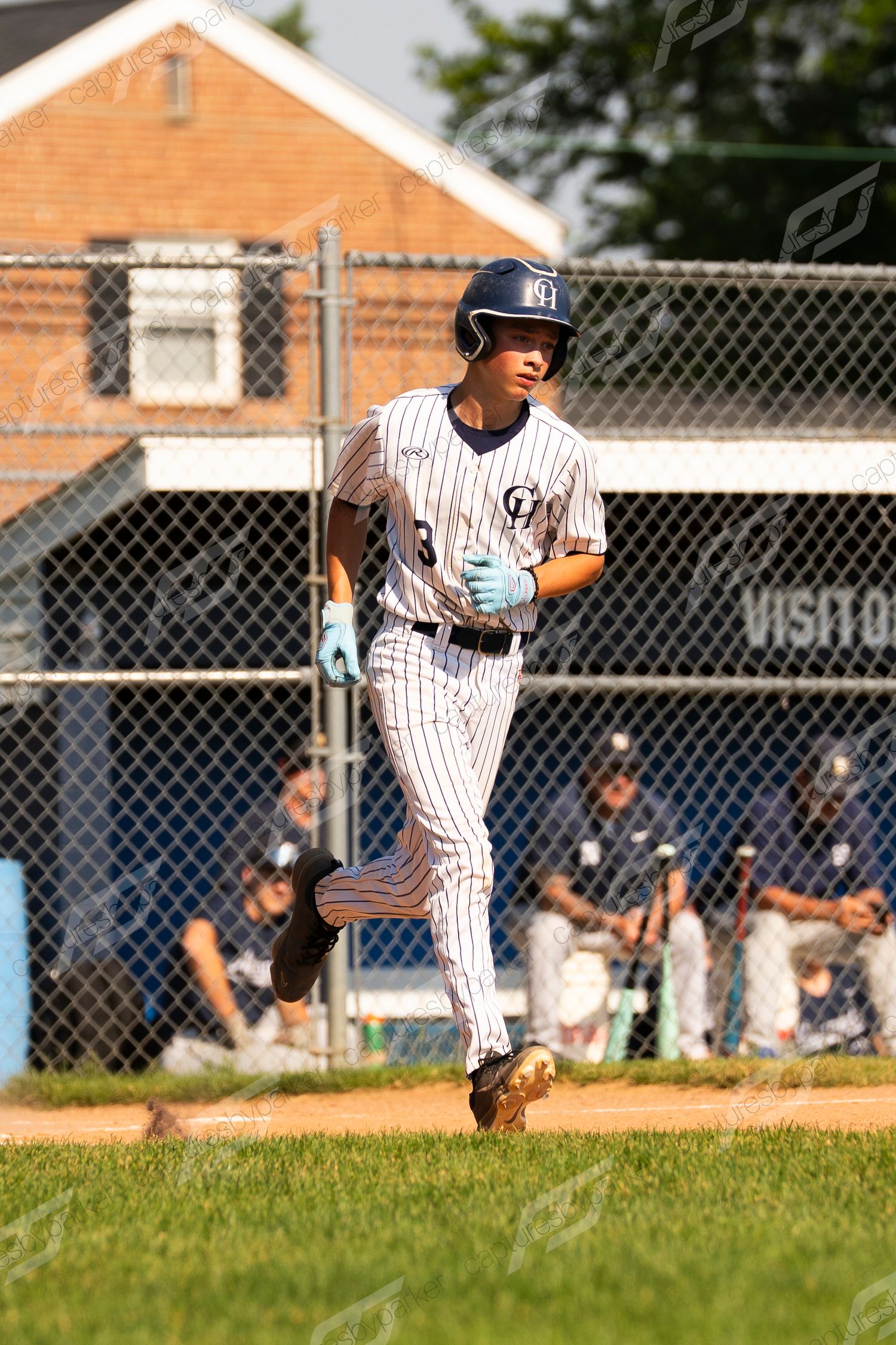 Baseball player #3 in pinstripe uniform and helmet jogs toward home plate during a sunny game.