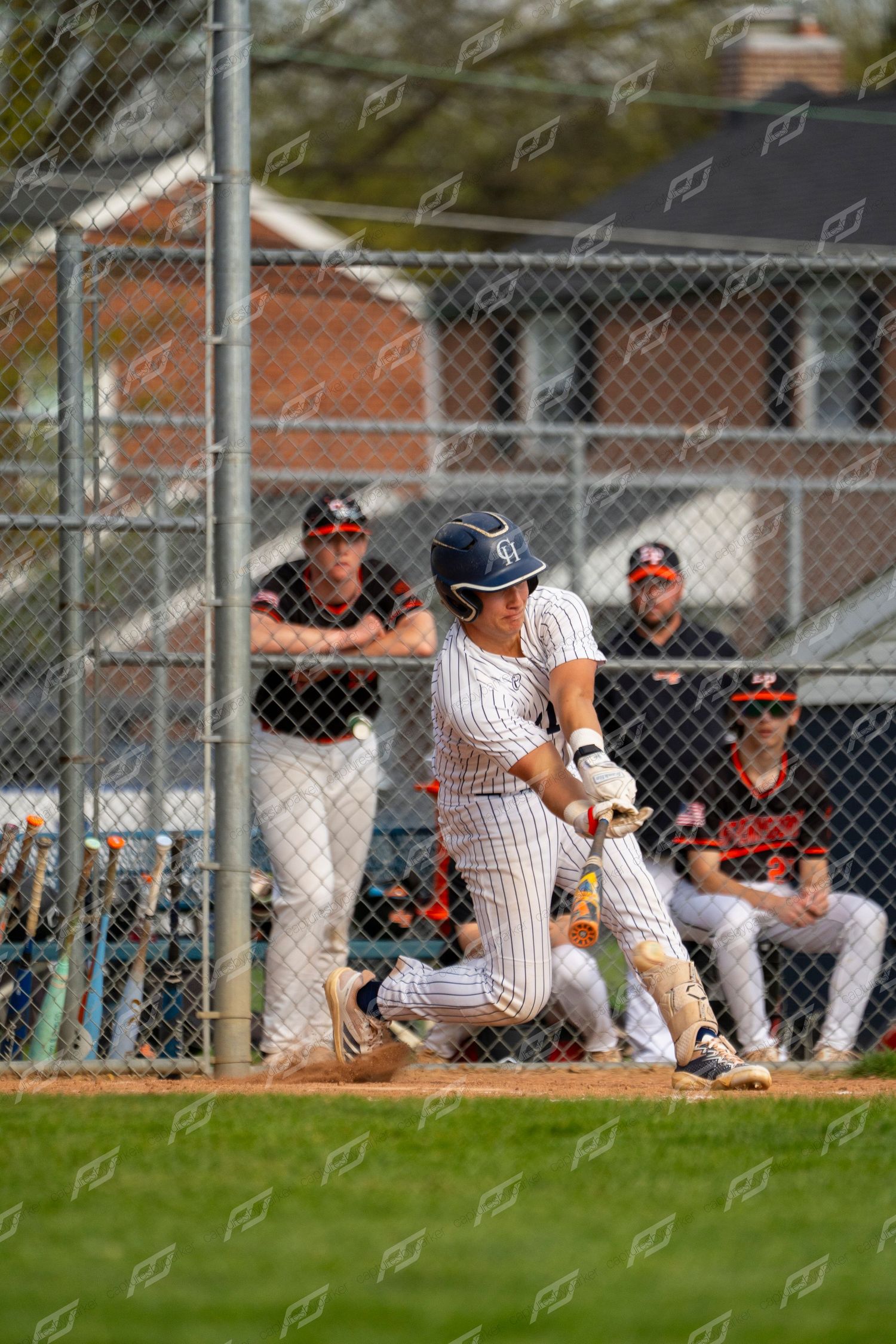 Baseball batter in white pinstripe uniform makes contact with the ball during a game.
