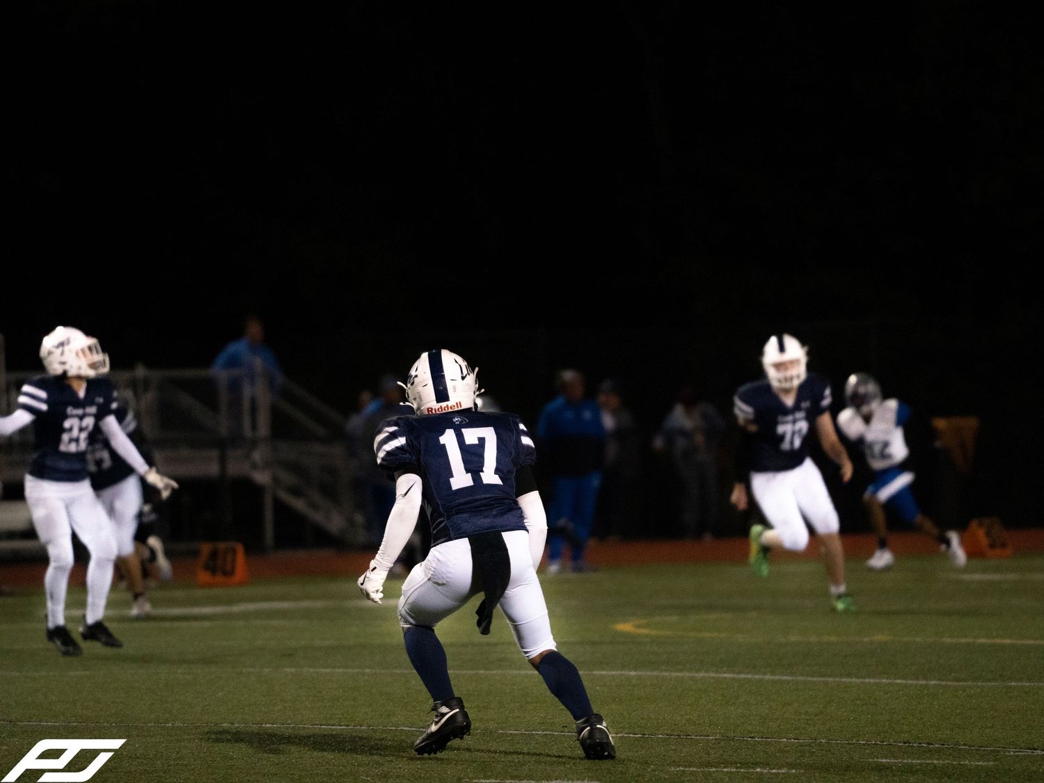 Camp Hill Lions football player number 17 prepares to make a play during a night game.