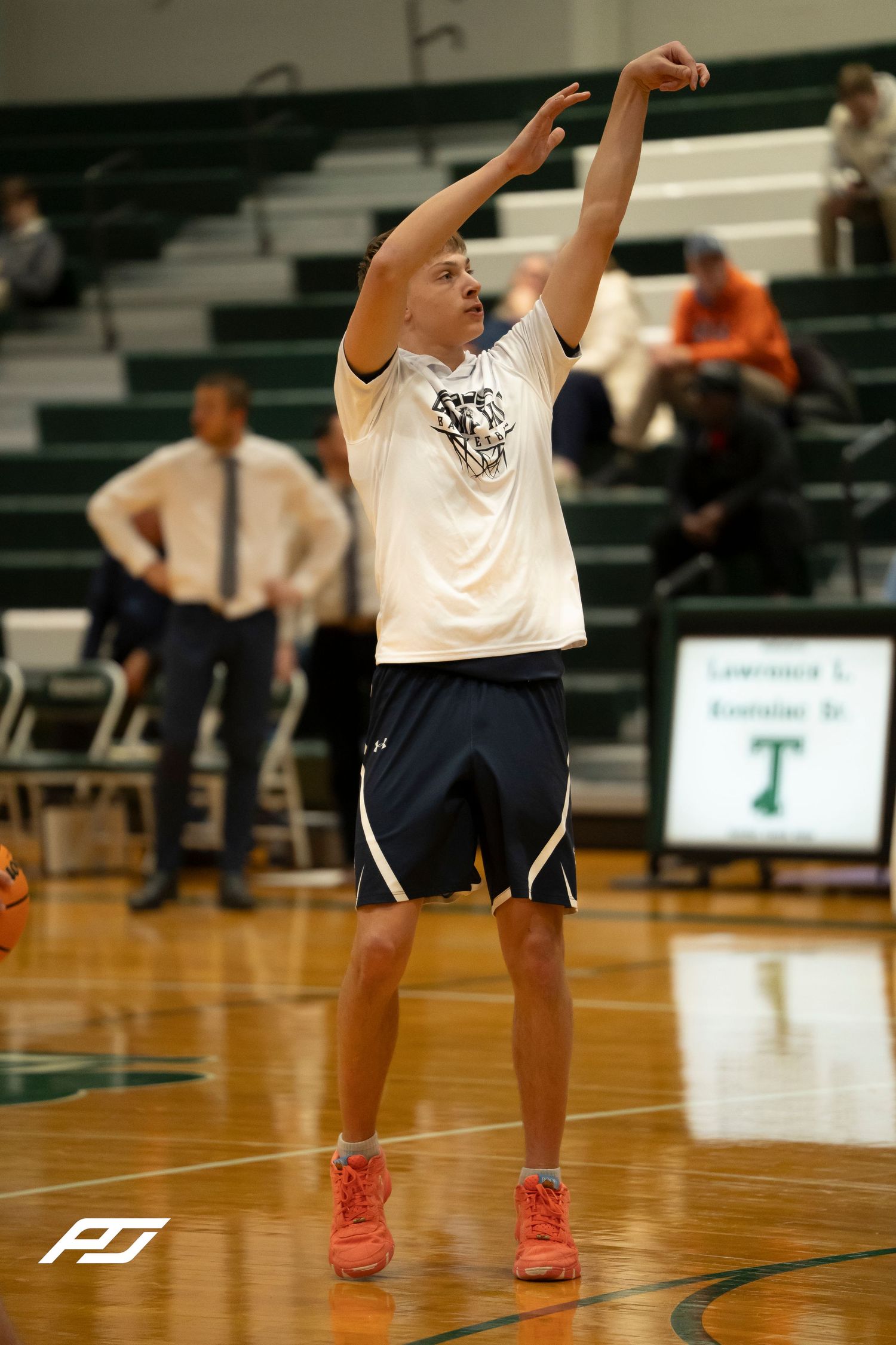 Basketball player in white Camp Hill uniform practices shooting form during pre-game warmups.