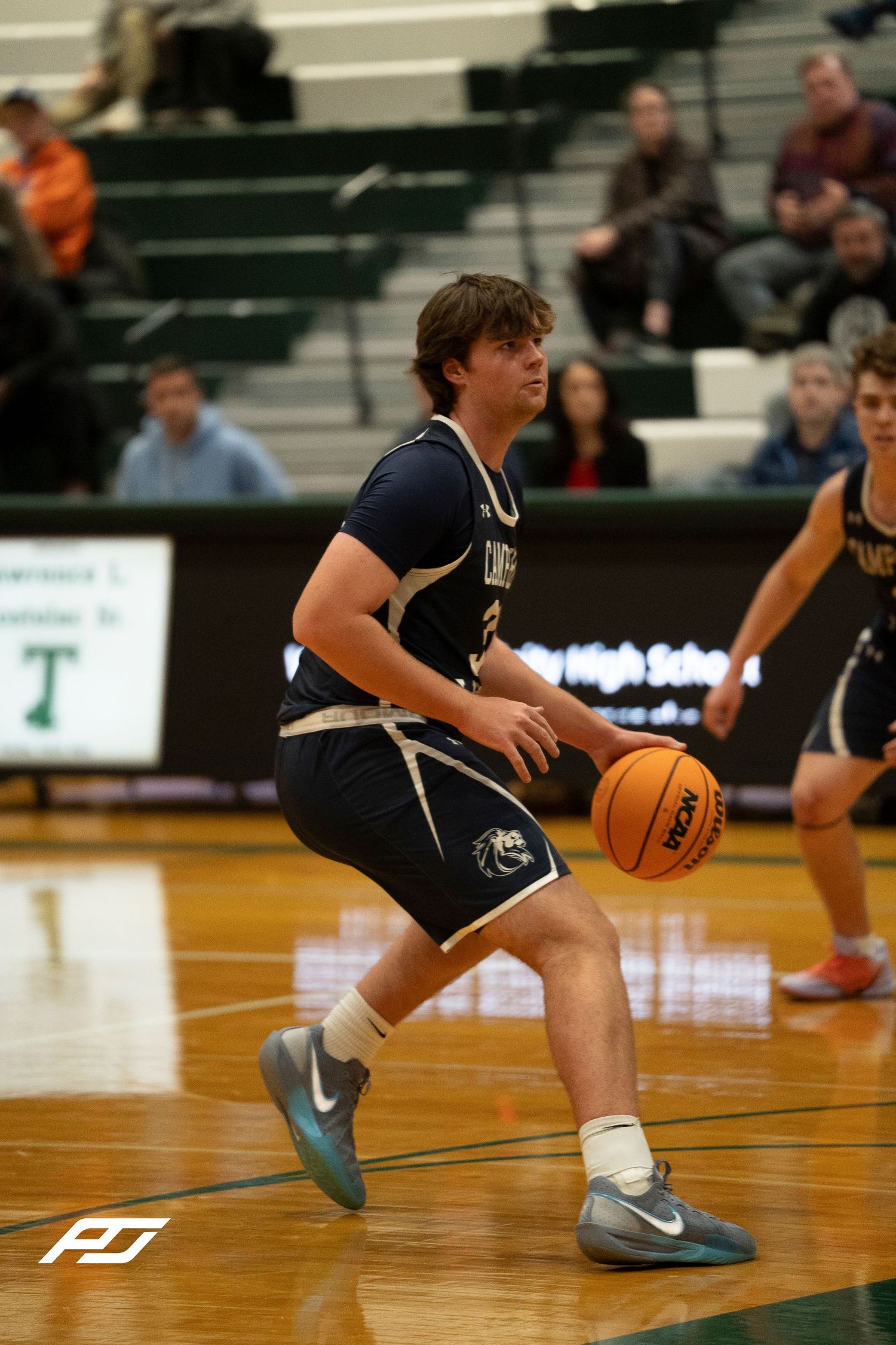 Camp Hill Lions basketball player drives with the ball during a competitive high school game.