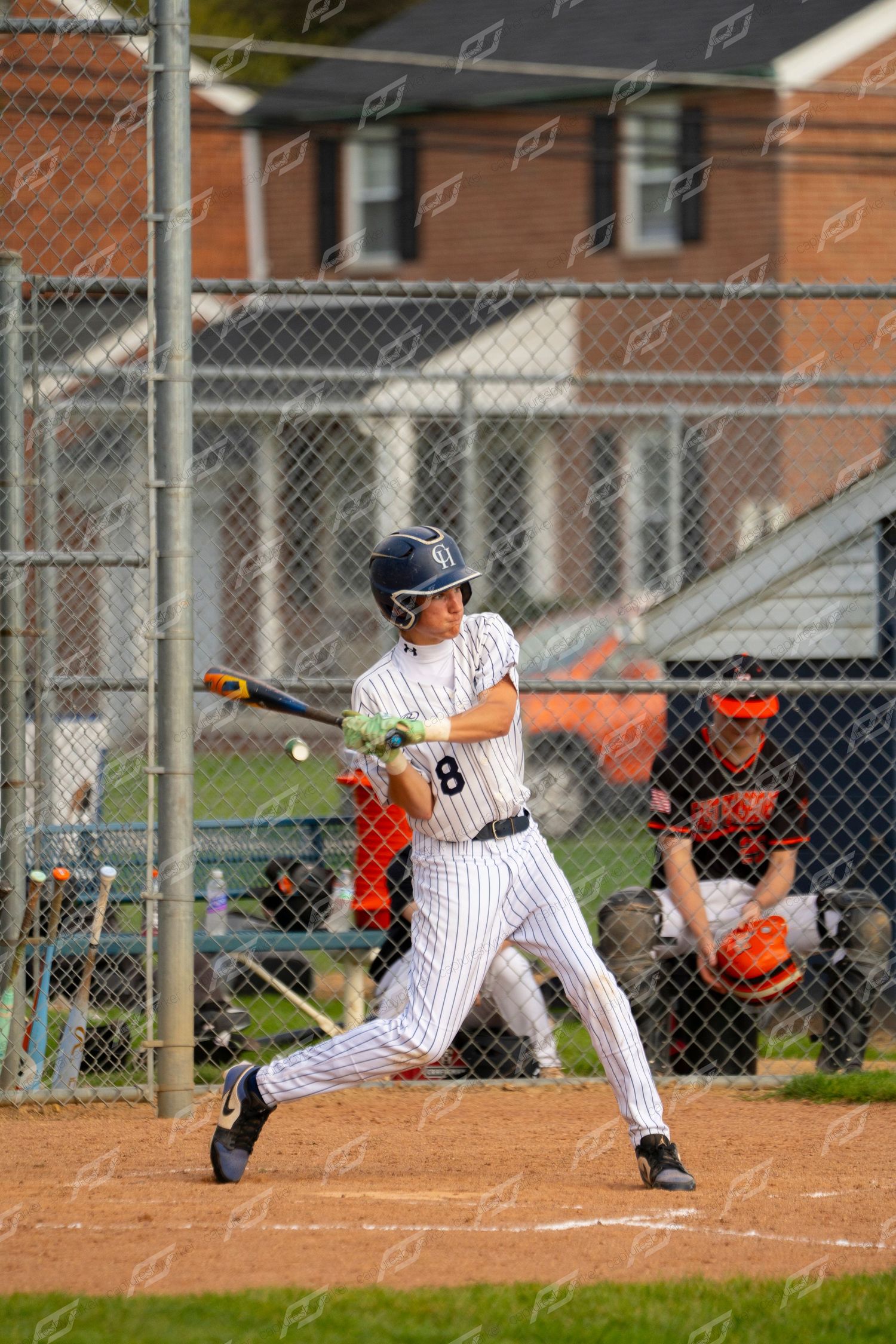 Baseball player number 8 in pinstripe uniform swinging at a pitch during a game.
