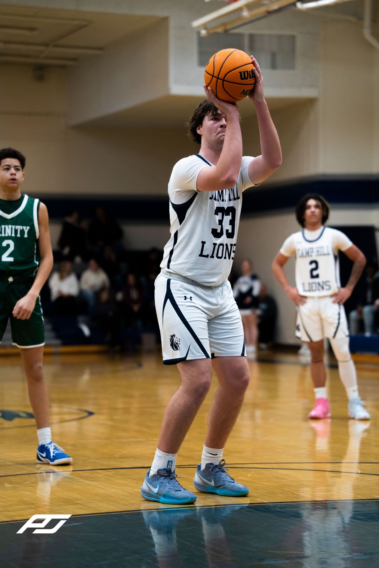 Camp Hill Lions player #33 shoots free throw during home basketball game against Trinity High School.