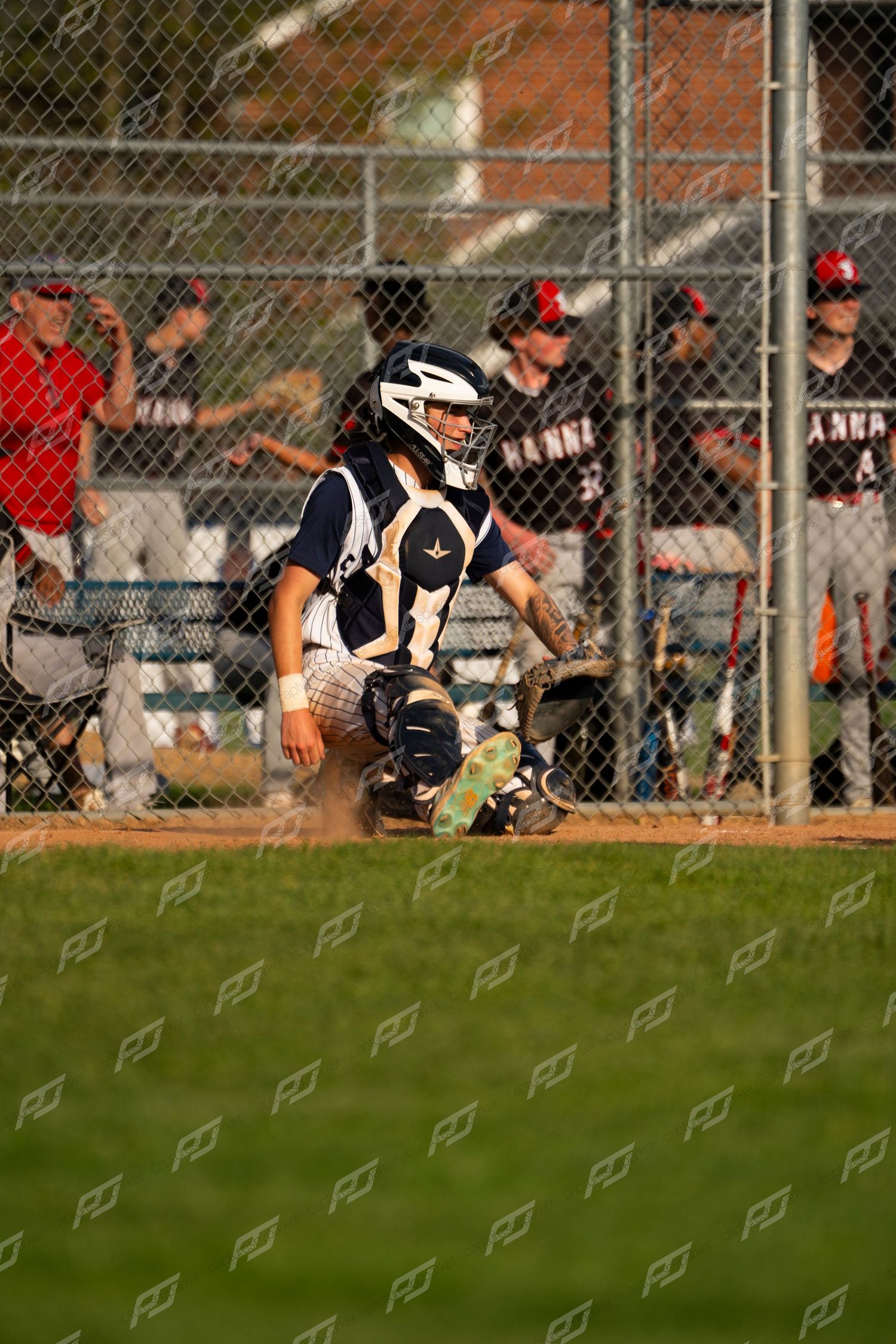 Camp Hill baseball catcher in full gear crouches behind home plate during a competitive youth baseball game.