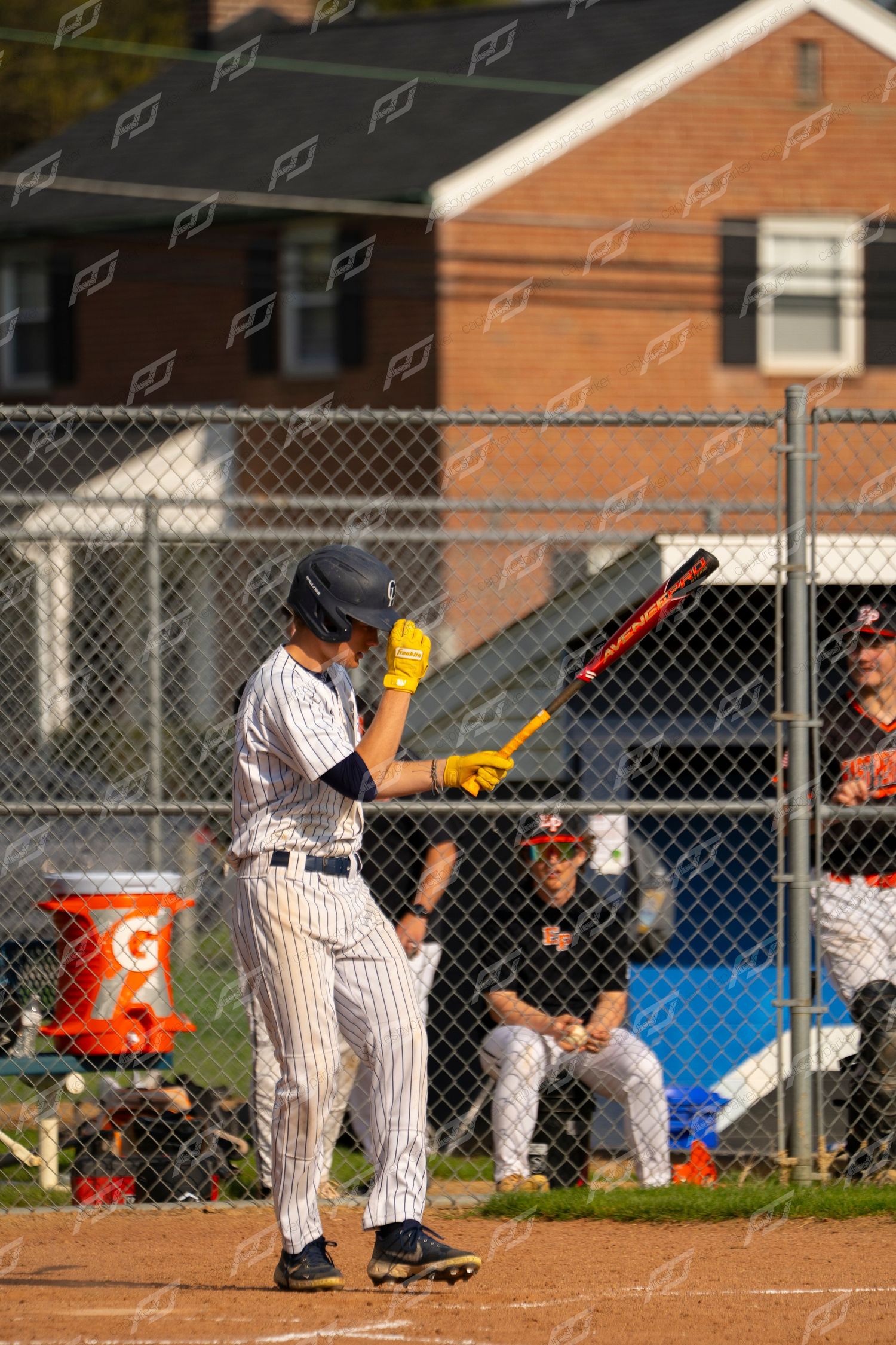 Baseball player #16 in white pinstripe uniform adjusting batting helmet at home plate.
