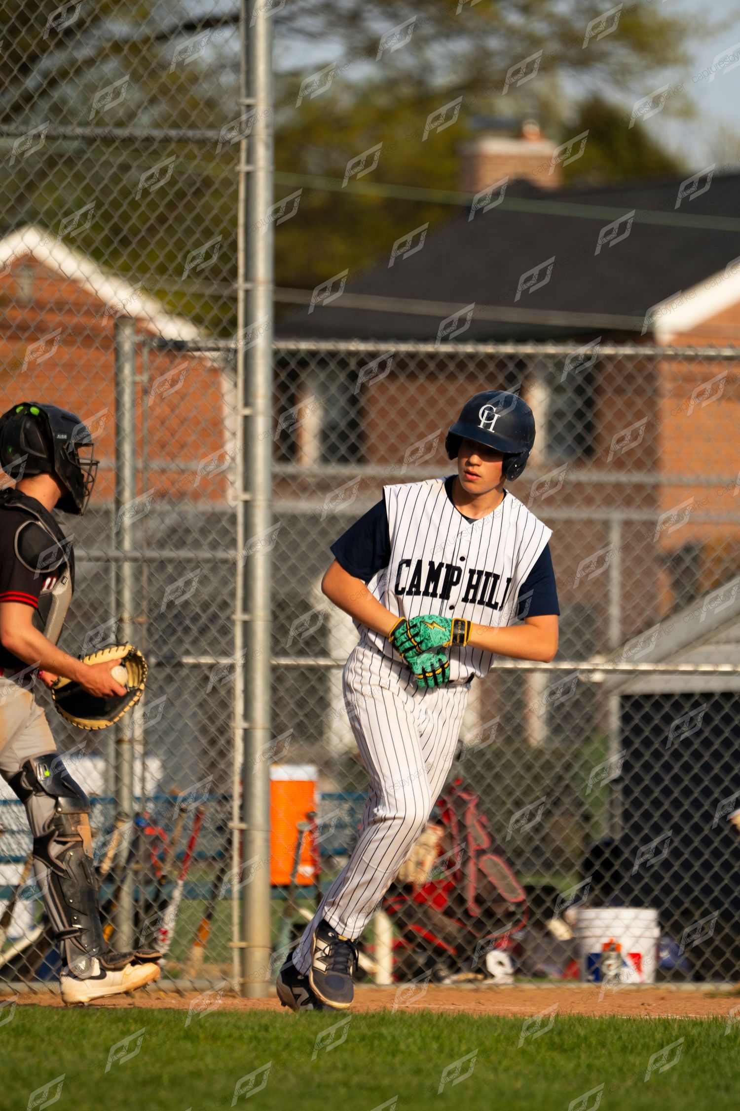 Camp Hill baseball batter approaches home plate with catcher in background.