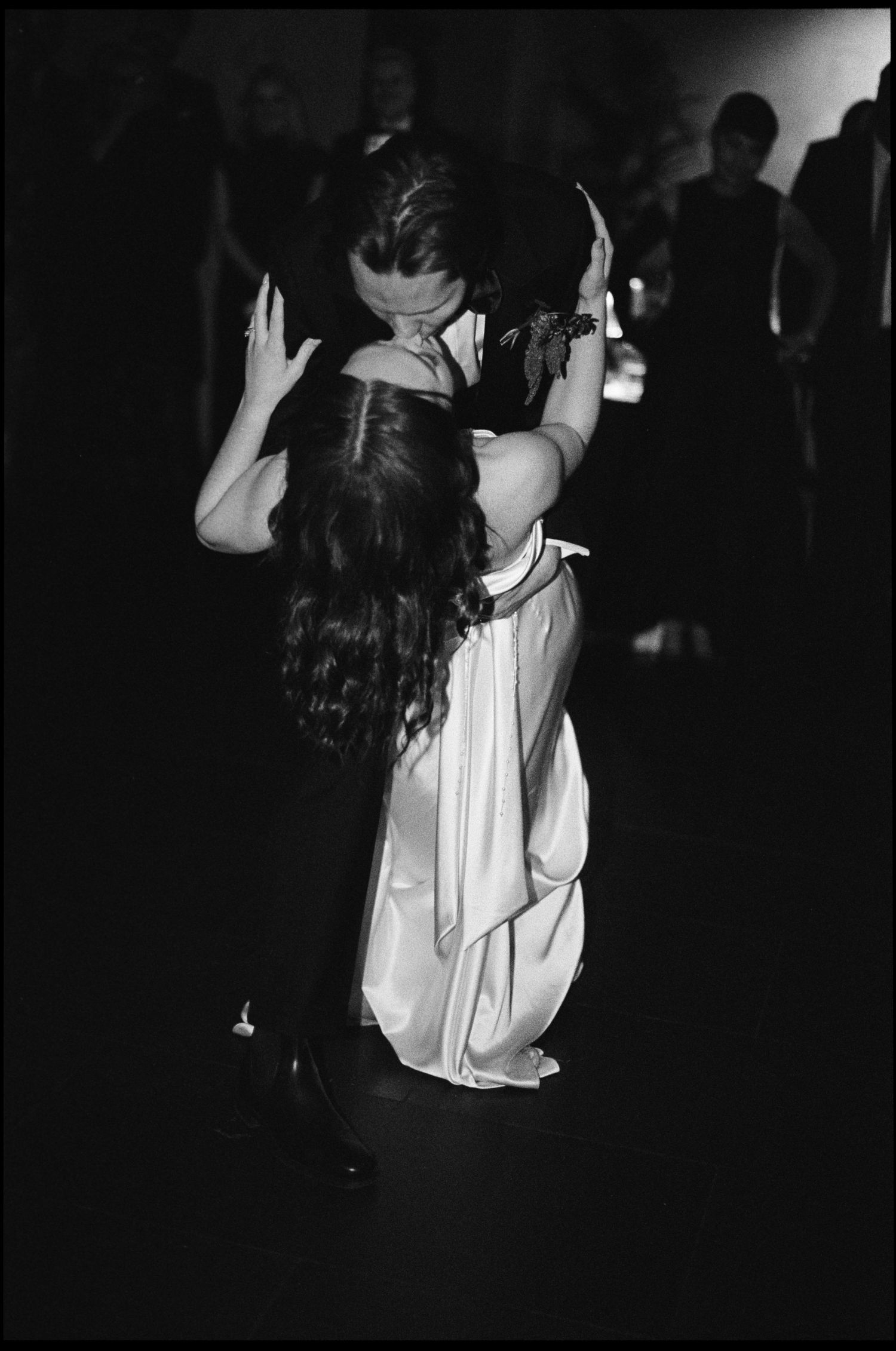 Black and white photo of a bride and groom sharing an intimate dance embrace at their wedding reception.