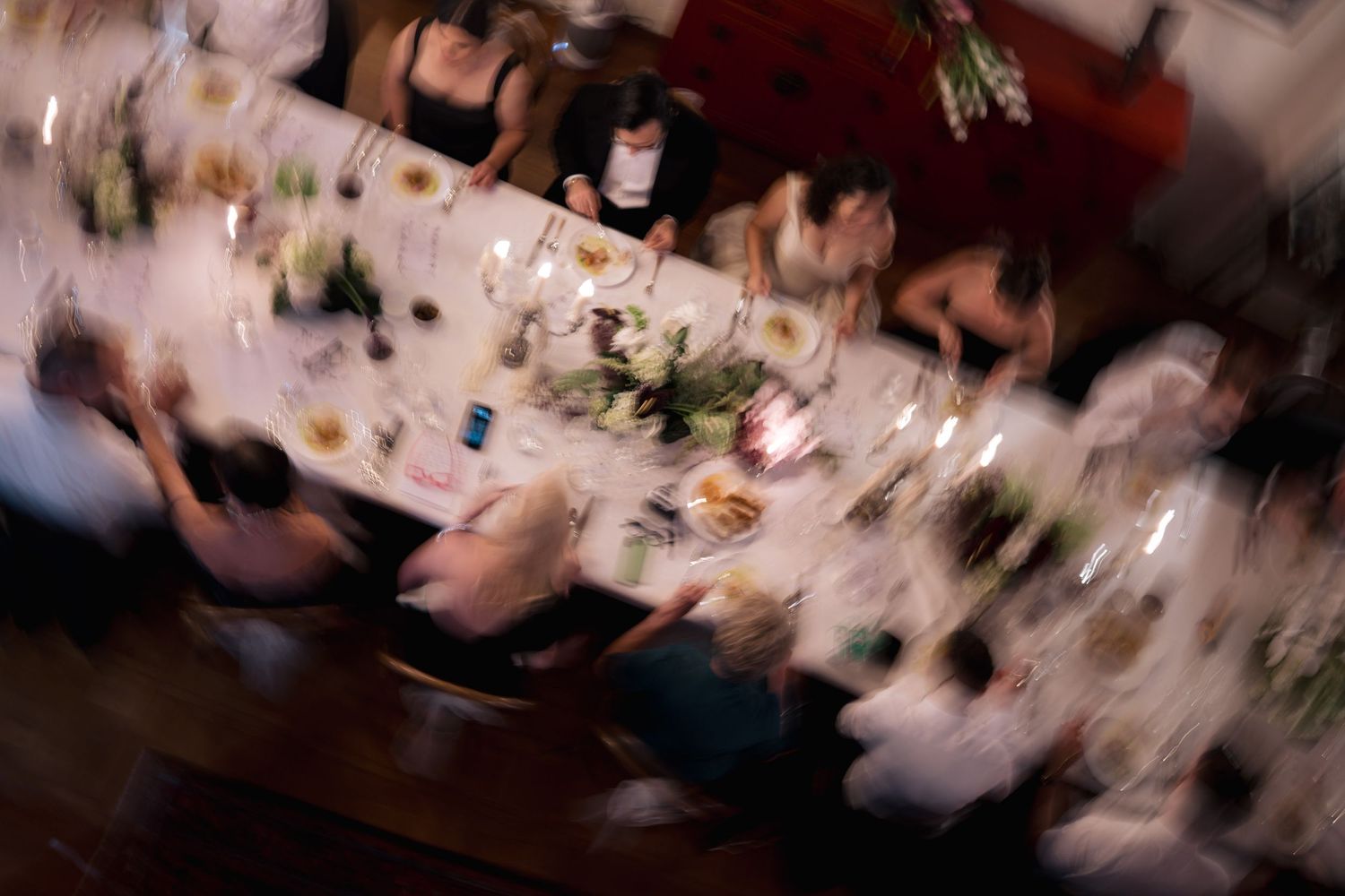 Blurred overhead view of a formal dinner table setting.