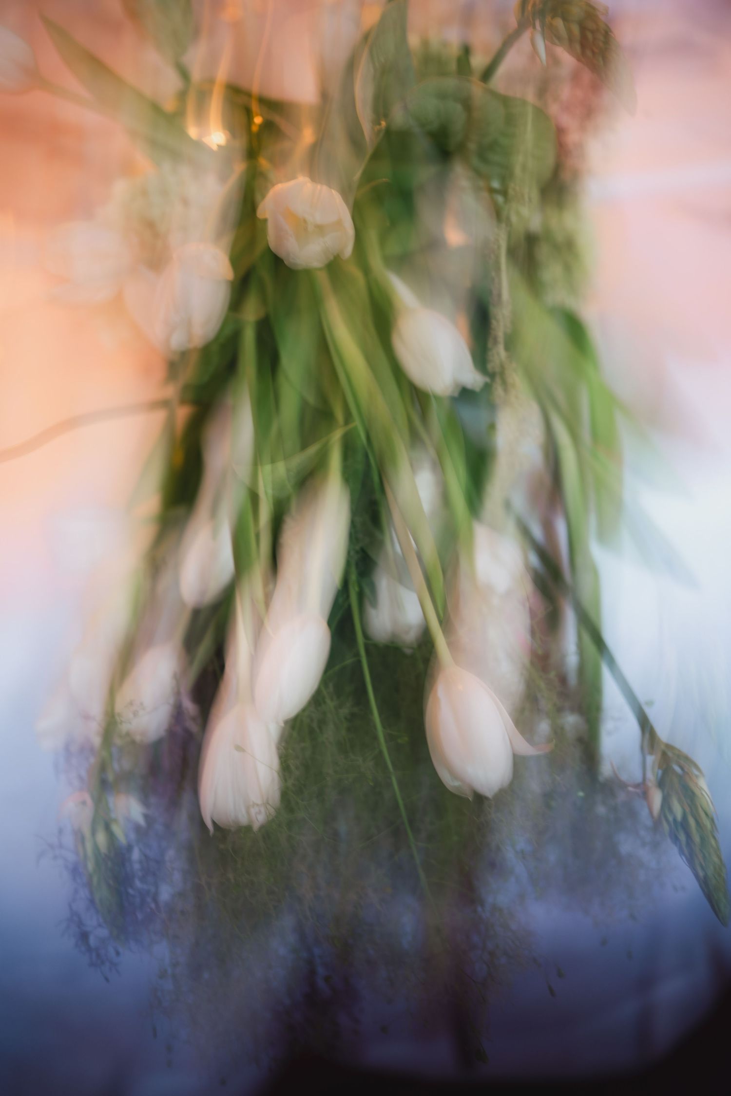 Artistic blurred floral image with soft pink and green tones.