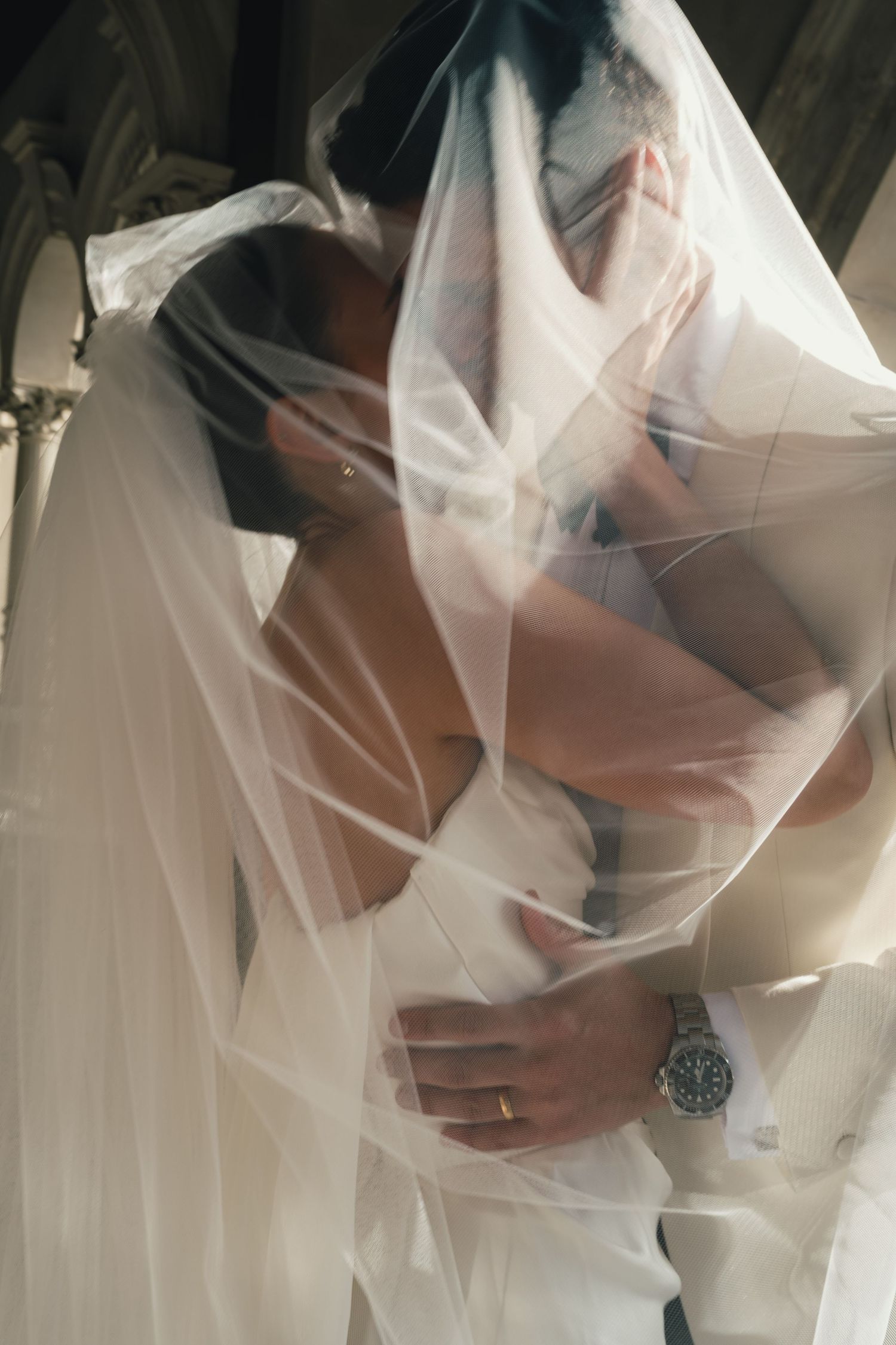 Close-up details of delicate white wedding veil fabric flowing in an ethereal pattern.