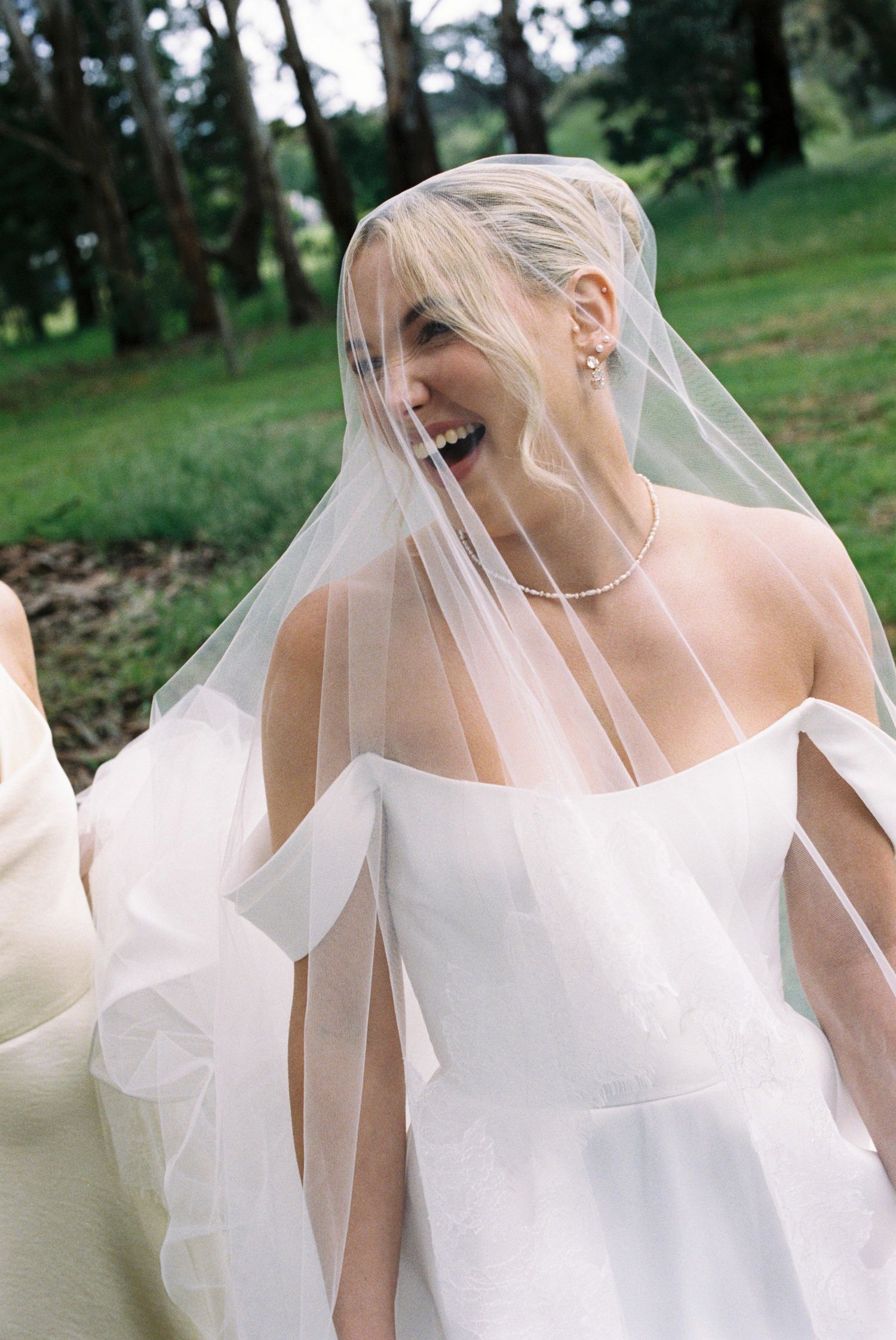 Ethereal bridal photos with flowing veil against natural outdoor backdrop.