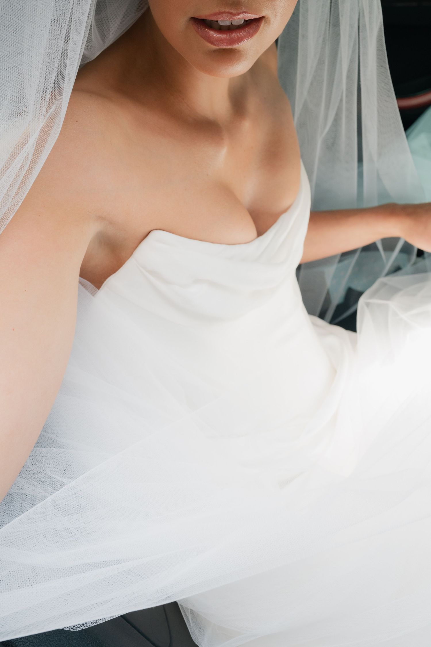 Ethereal close-up details of white wedding dress and veil.