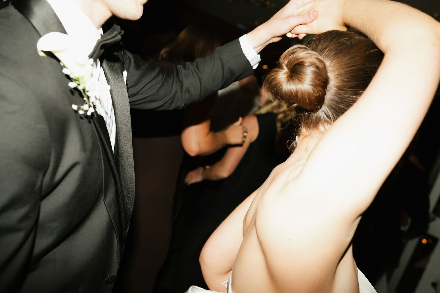 Wedding couple shares an intimate dance moment in formal attire.