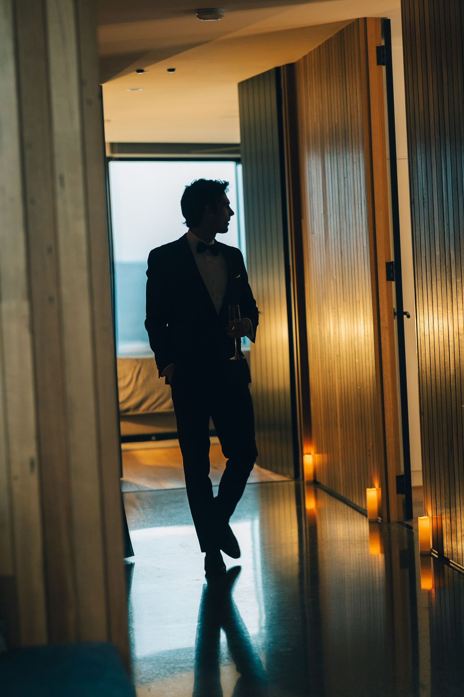 Silhouette walking through modern hallway with ambient lighting.