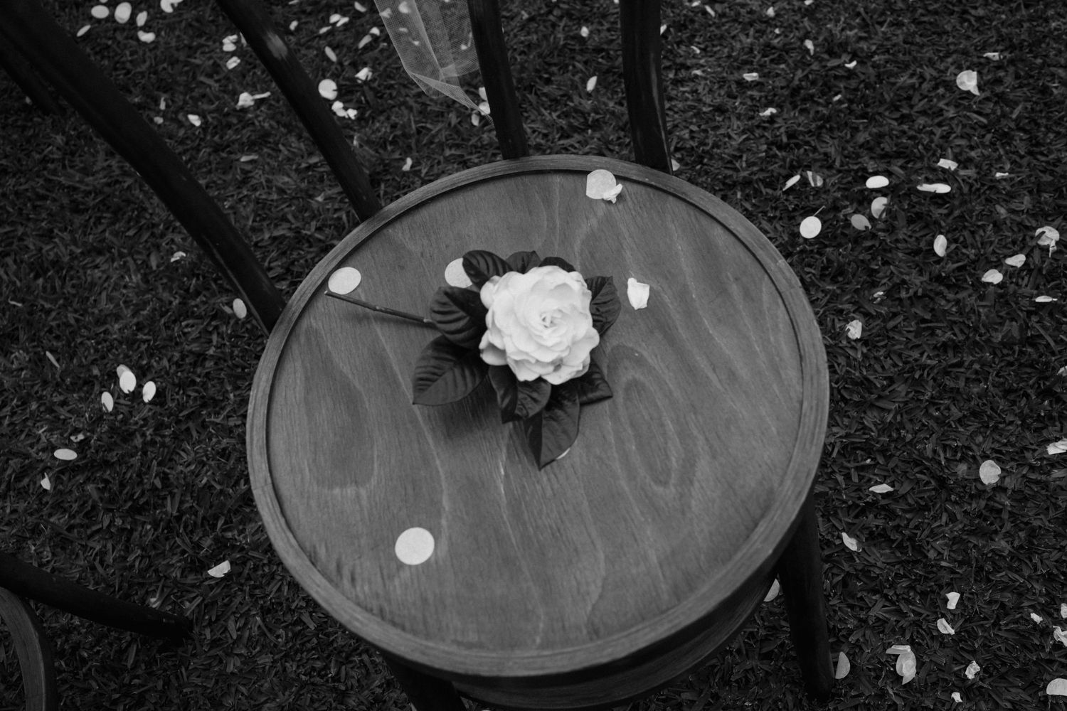 A black and white photo shows a collection of vintage vinyl records scattered on a dark surface.